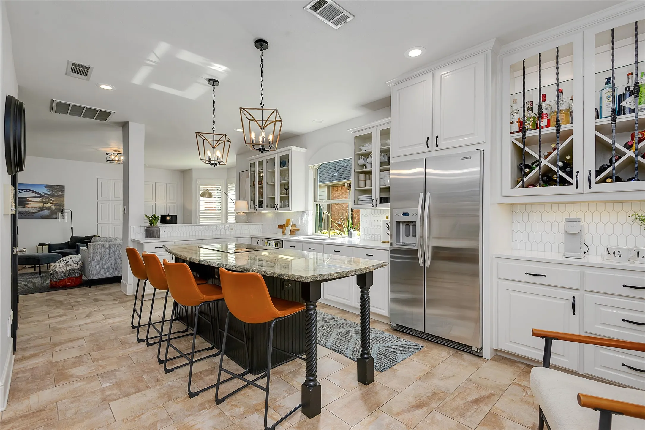 Open-concept kitchen featuring an oversized island with a granite countertop and seating for four