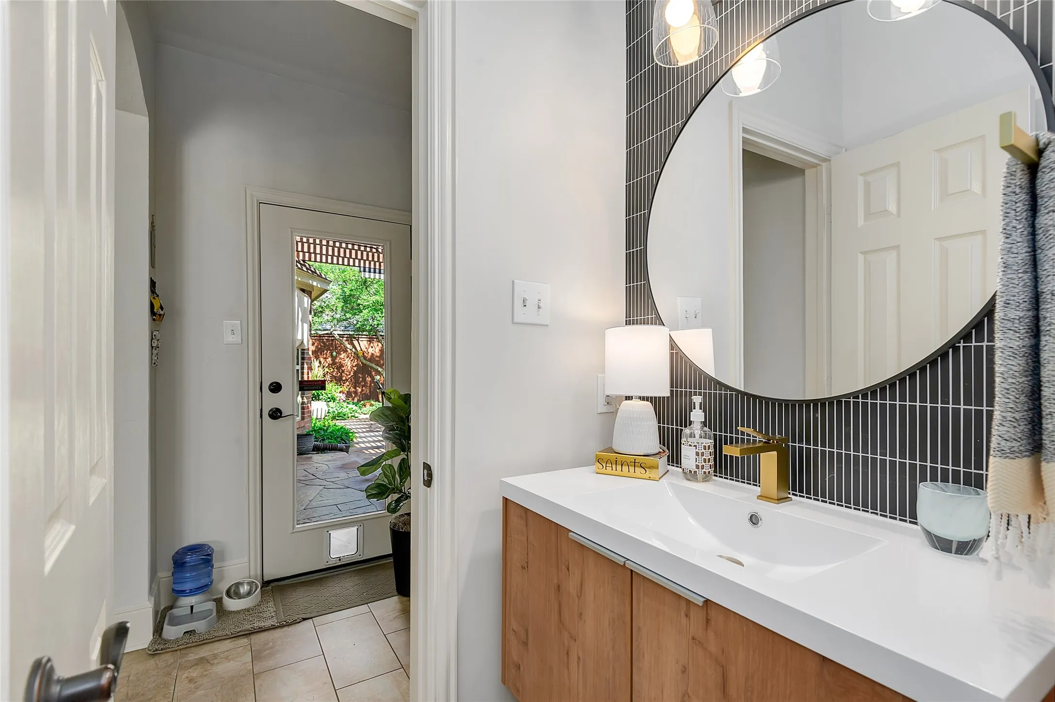 Modern vanity with a gold-finish faucet, white countertop, and wood-finish cabinetry