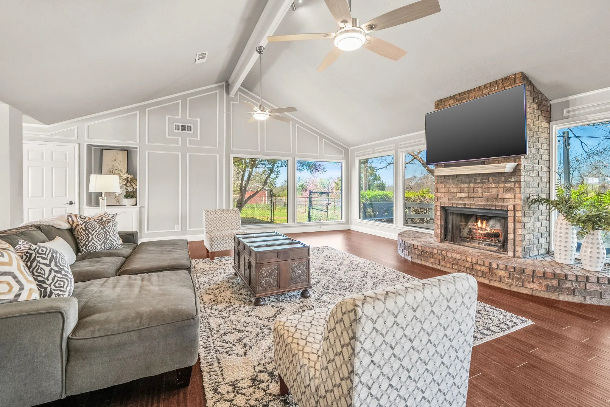 Living room with wall of windows and brick fireplace