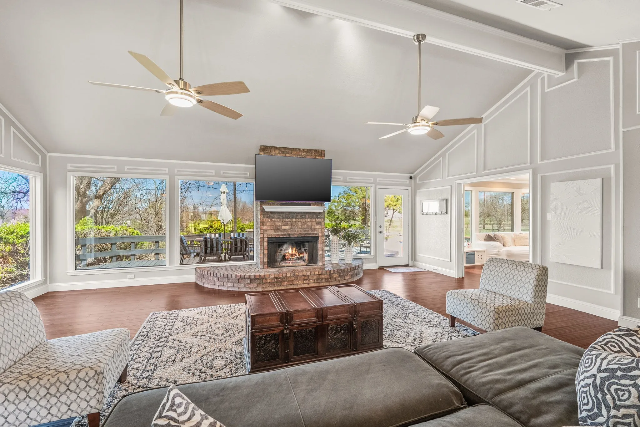 Open living room with wll of windows and brick fireplace