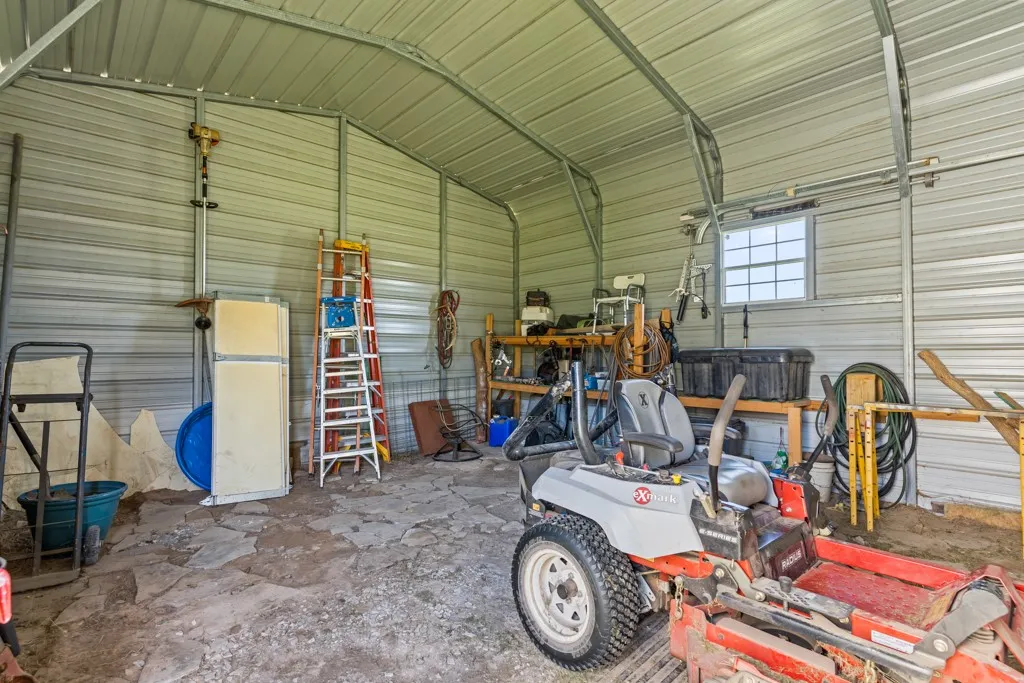 Metal utility building featuring corrugated metal walls and ceiling, exposed metal framing, and a single window