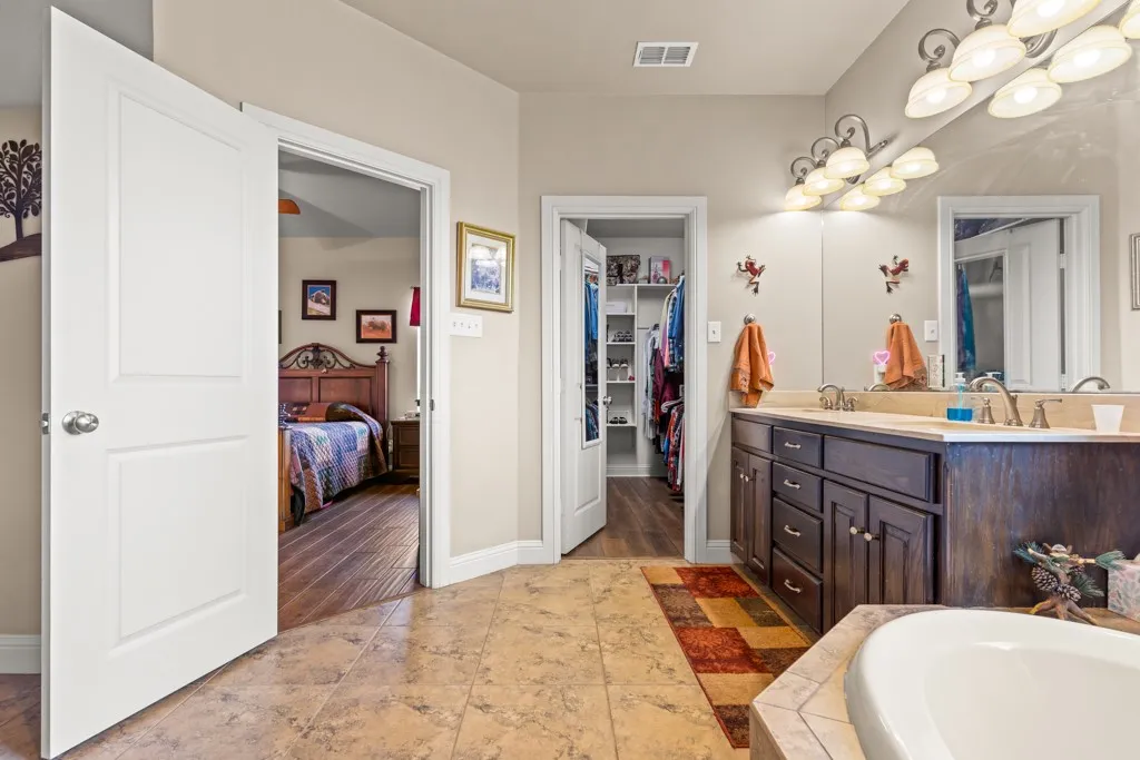 Bathroom featuring a double vanity with dark wood cabinetry, light-colored countertops, and dual framed mirrors