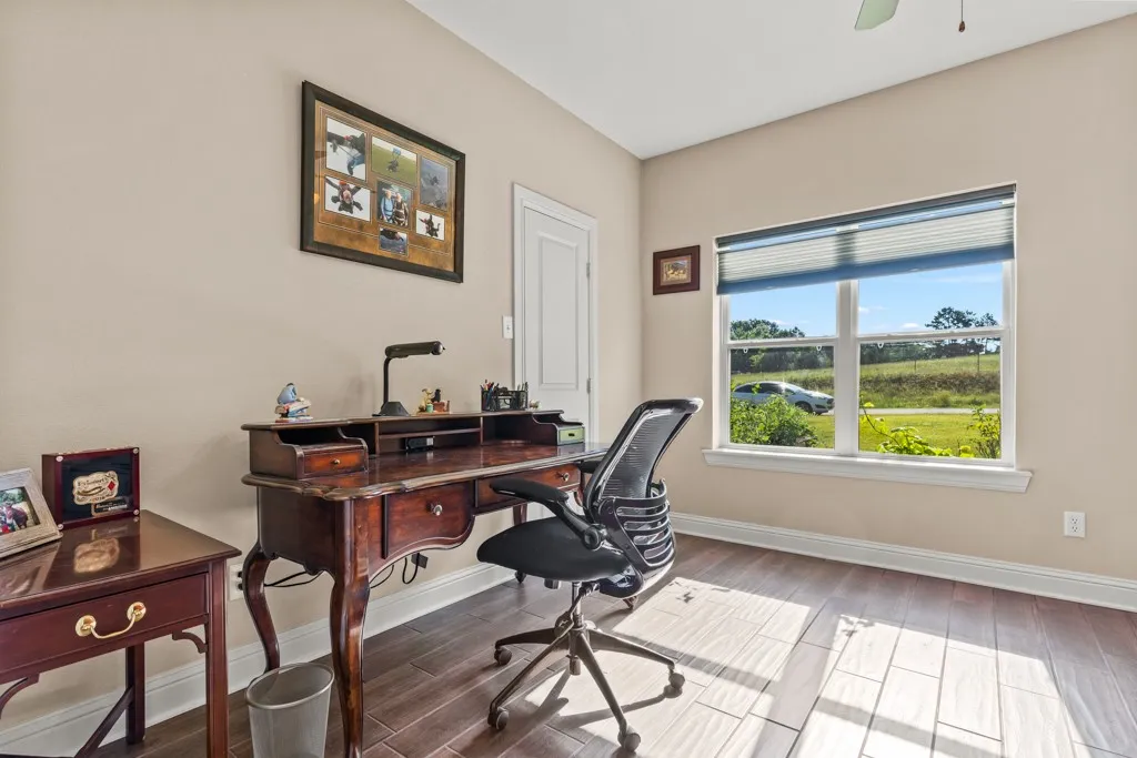 Room featuring wood-finish flooring, a neutral wall color, and a multi-pane window with a privacy blind