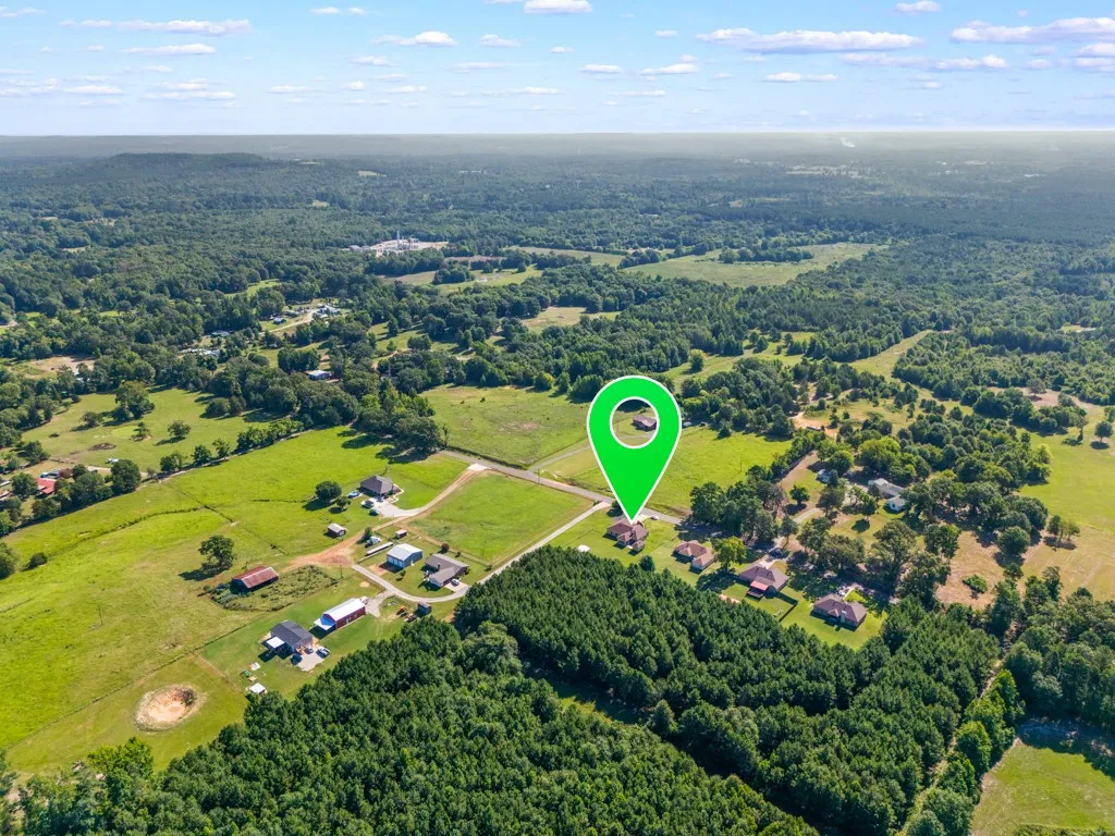 Expansive rural landscape featuring a mix of open fields and dense tree lines