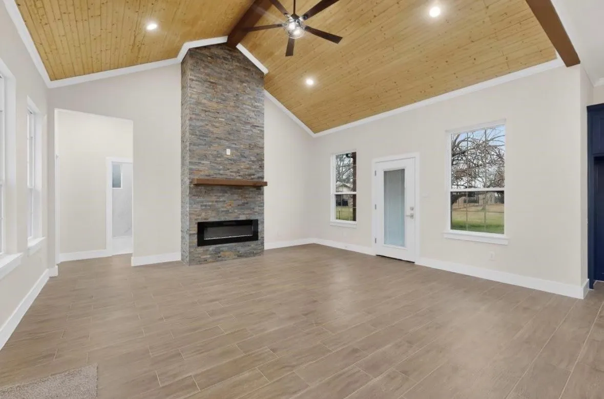 Vaulted wood-plank ceiling with exposed beams and recessed lighting