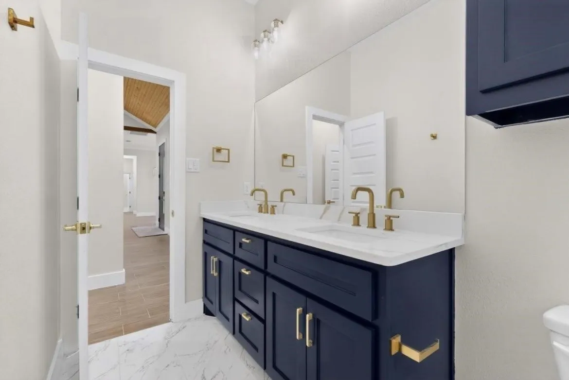 Double vanity with a white countertop and gold-finish fixtures