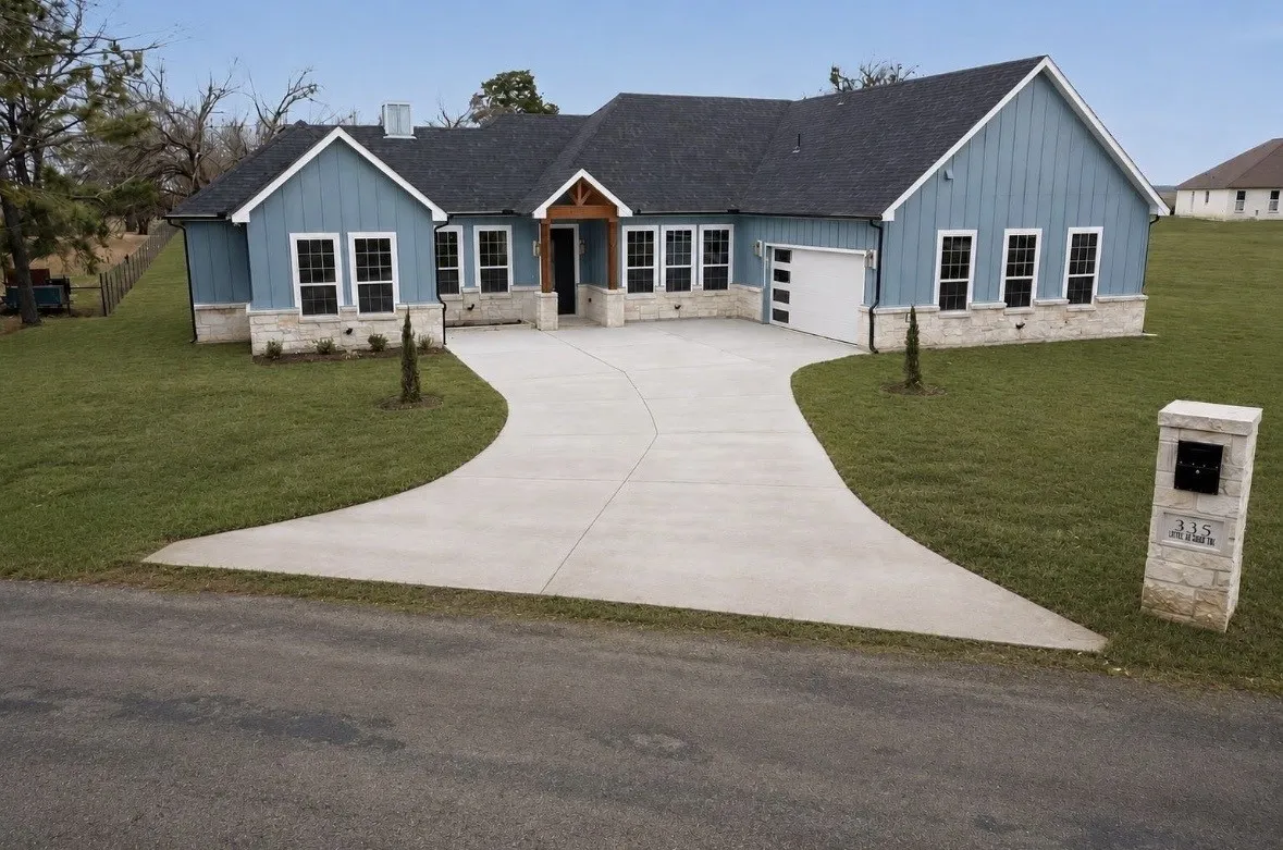 Contemporary exterior with light blue vertical siding and a stone skirt