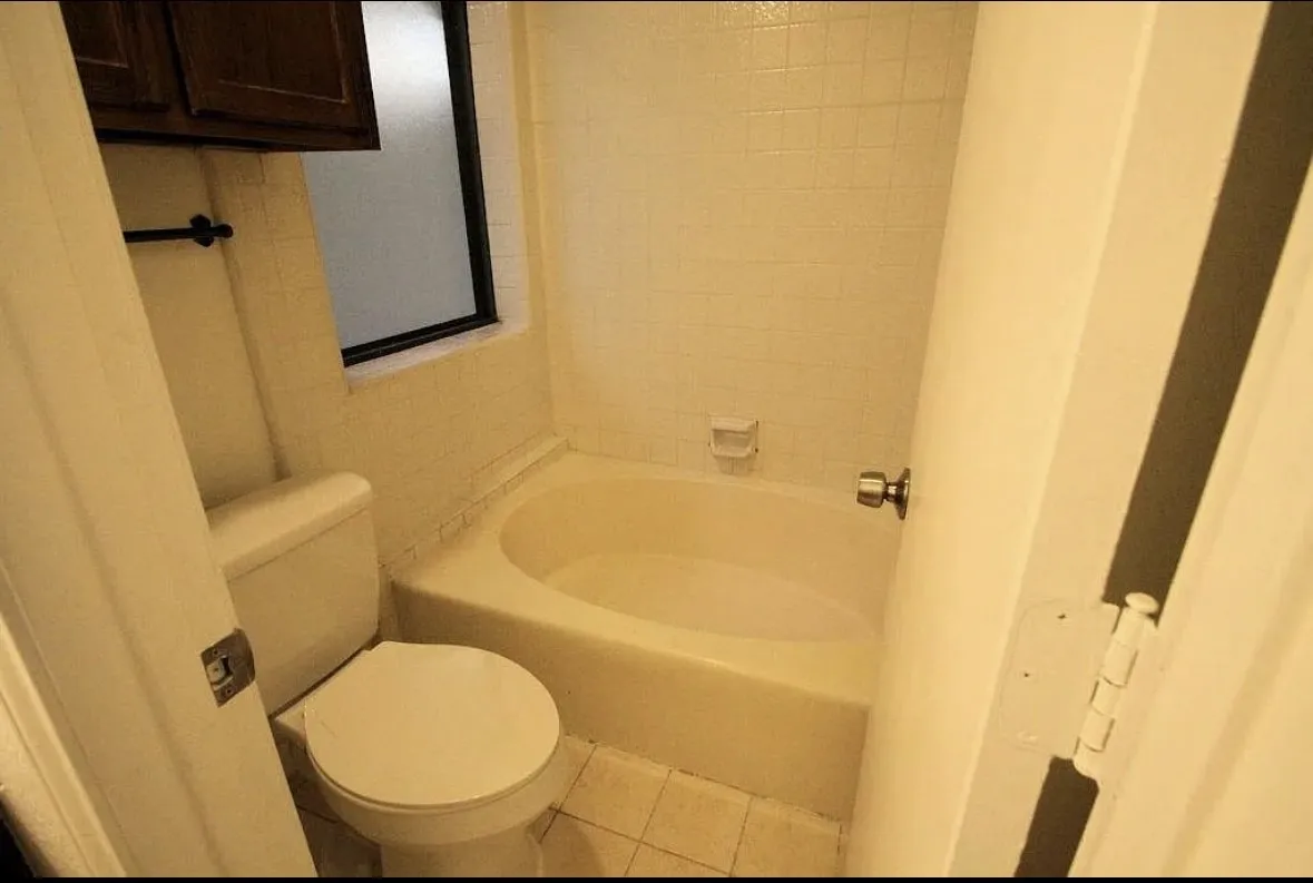 Full bath featuring toilet and tile patterned flooring