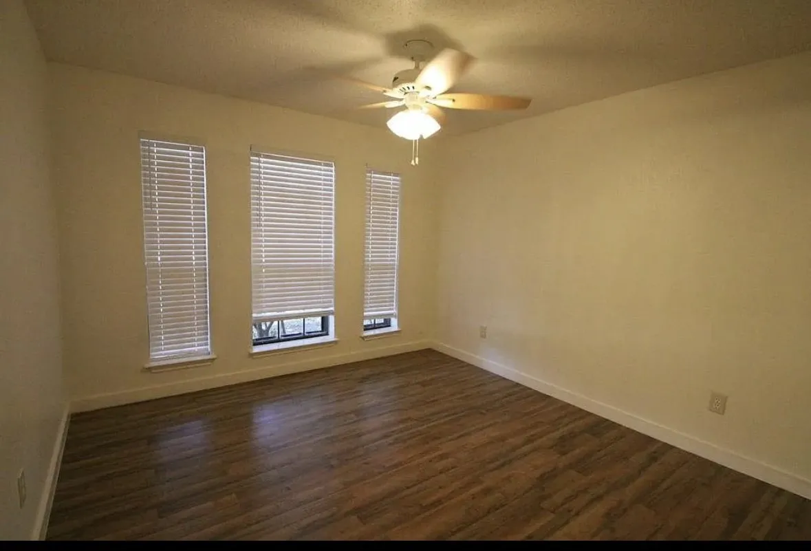 Spare room with a ceiling fan and dark wood finished floors