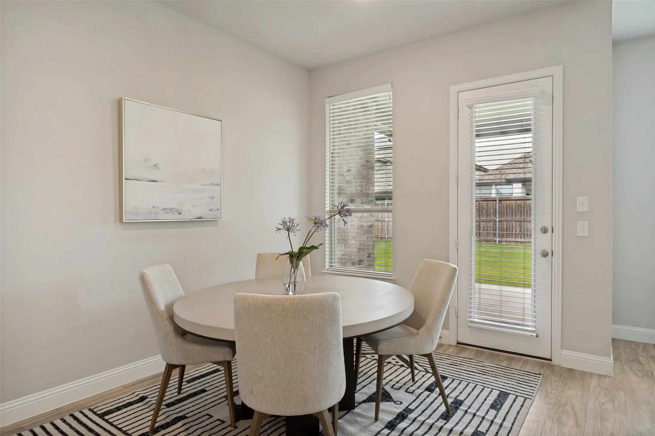 Bright and inviting breakfast nook with large windows and direct access to the covered patio and backyard. This charming dining space offers the perfect setting for casual meals, morning coffee, or gathering with family while enjoying views of the outdoor living area.