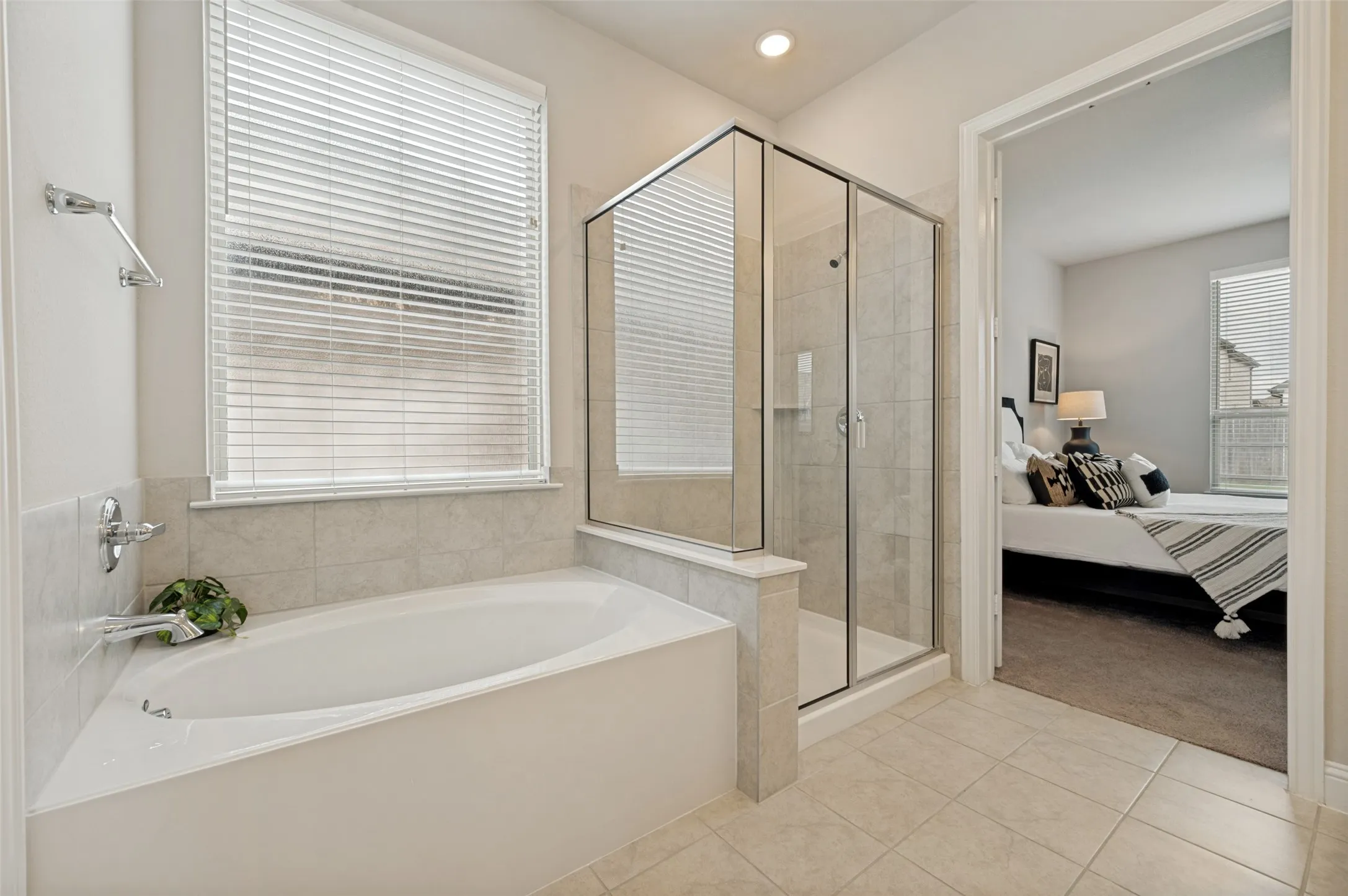 Enjoy a spa-like experience in the luxurious primary bathroom featuring a relaxing soaking tub, oversized walk-in shower with glass enclosure, elegant tile finishes, and abundant natural light. Thoughtfully designed for comfort and functionality, this private retreat offers the perfect place to unwind after a long day.