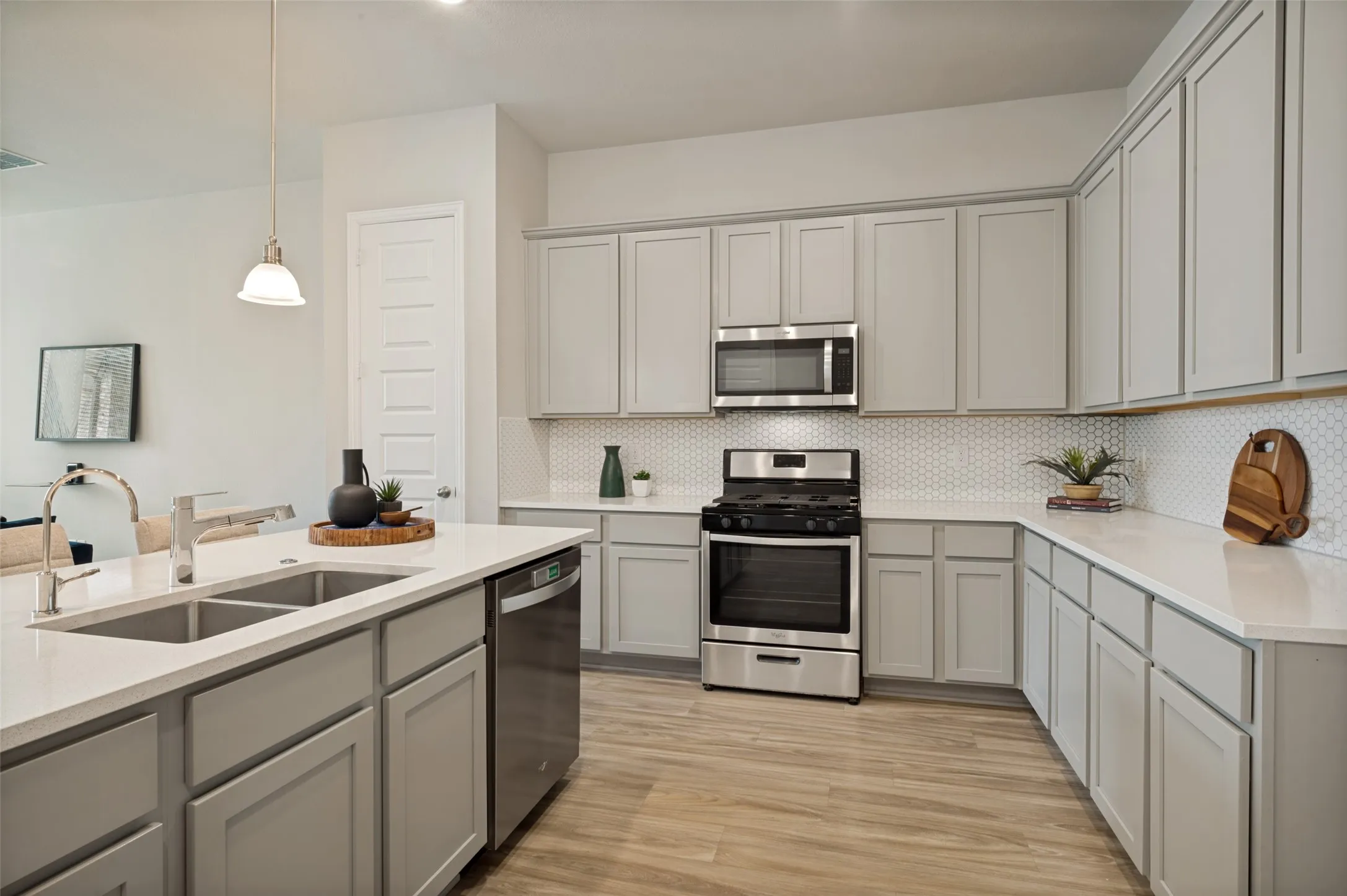 The heart of the home, this stunning open-concept kitchen features a large quartz island with seating, stainless steel appliances, abundant cabinetry, and seamless flow into the dining and living areas. Perfect for entertaining, the bright and airy layout offers beautiful backyard views and effortless everyday living.