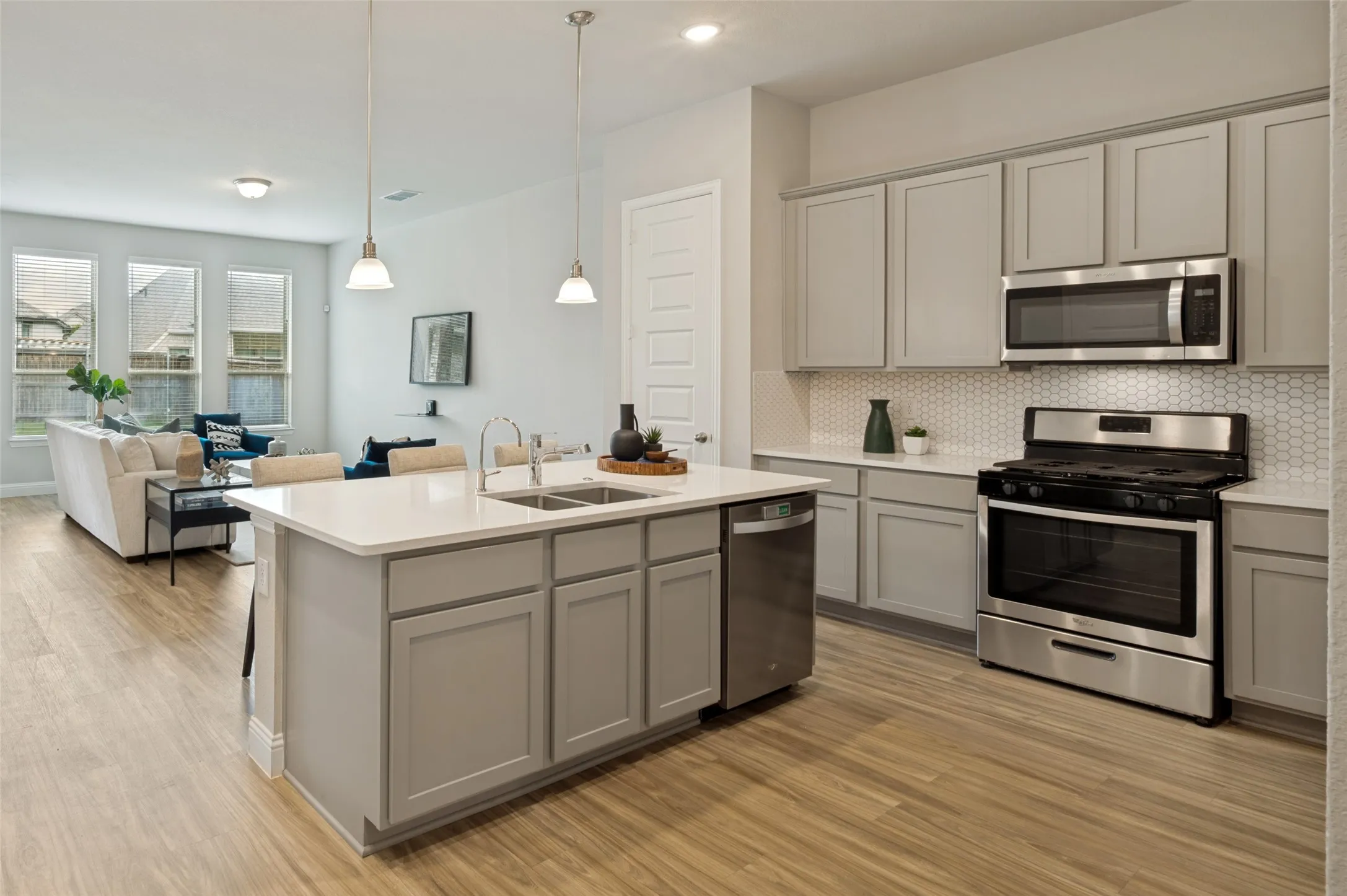 Designed for modern living, this bright open-concept floor plan seamlessly connects the kitchen, dining, and family room. The chef-inspired kitchen features quartz countertops, a large center island, stainless steel appliances, gas cooking, and abundant cabinet space, creating the perfect setting for entertaining and everyday life