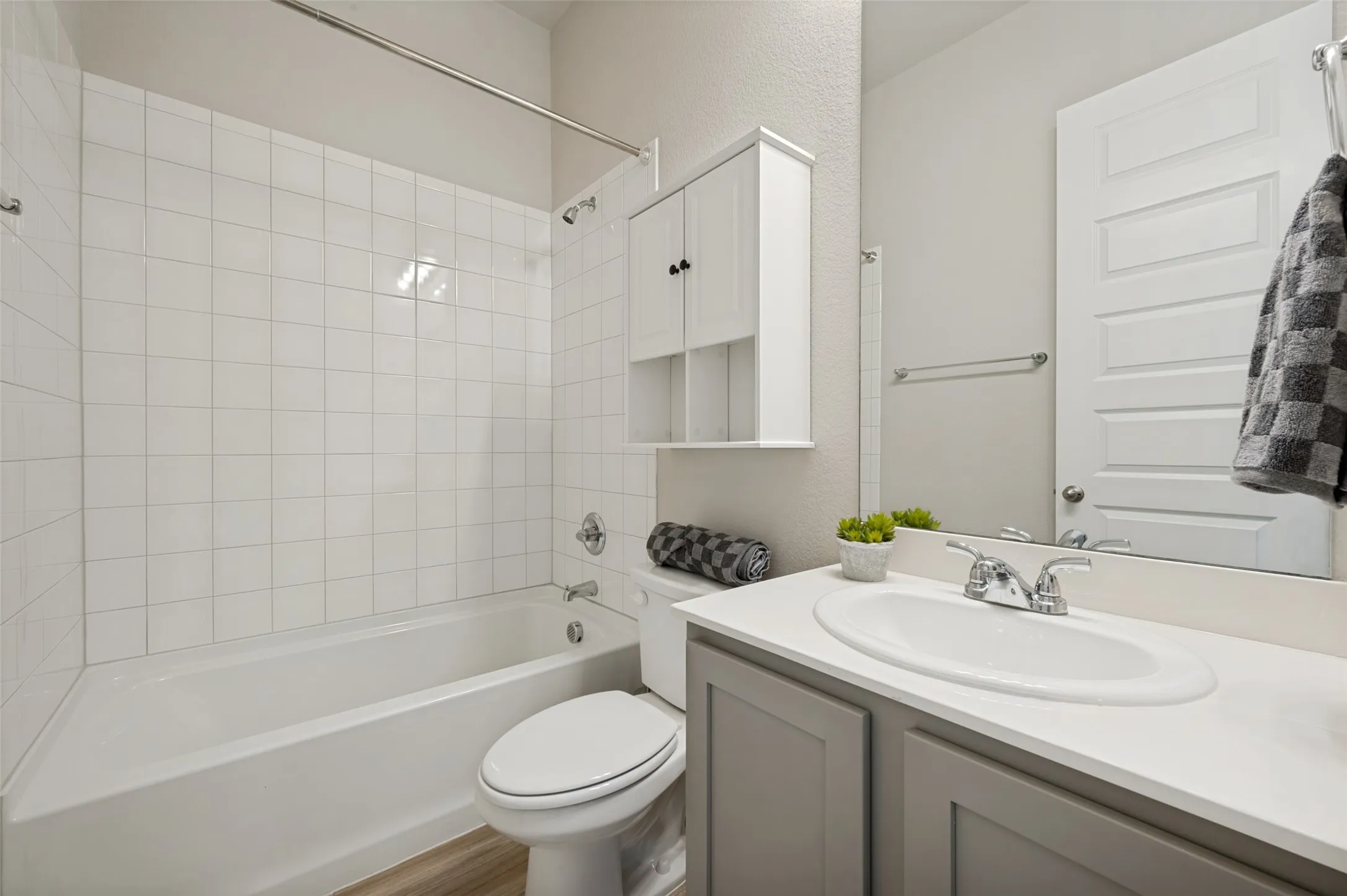 A well-appointed full bathroom serves the downstairs bedroom and guests with style and convenience. Featuring a spacious vanity, modern fixtures, ample storage, and a shower-tub combination, this bright and functional space is designed for everyday comfort and ease.