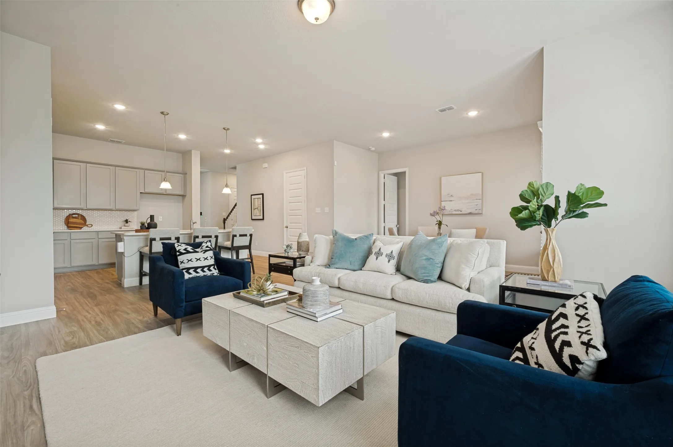 Spacious family room designed for comfort and connection, featuring an open-concept layout that flows seamlessly into the kitchen and dining areas. Large windows fill the space with natural light, creating a bright and welcoming atmosphere perfect for relaxing or entertaining guests.