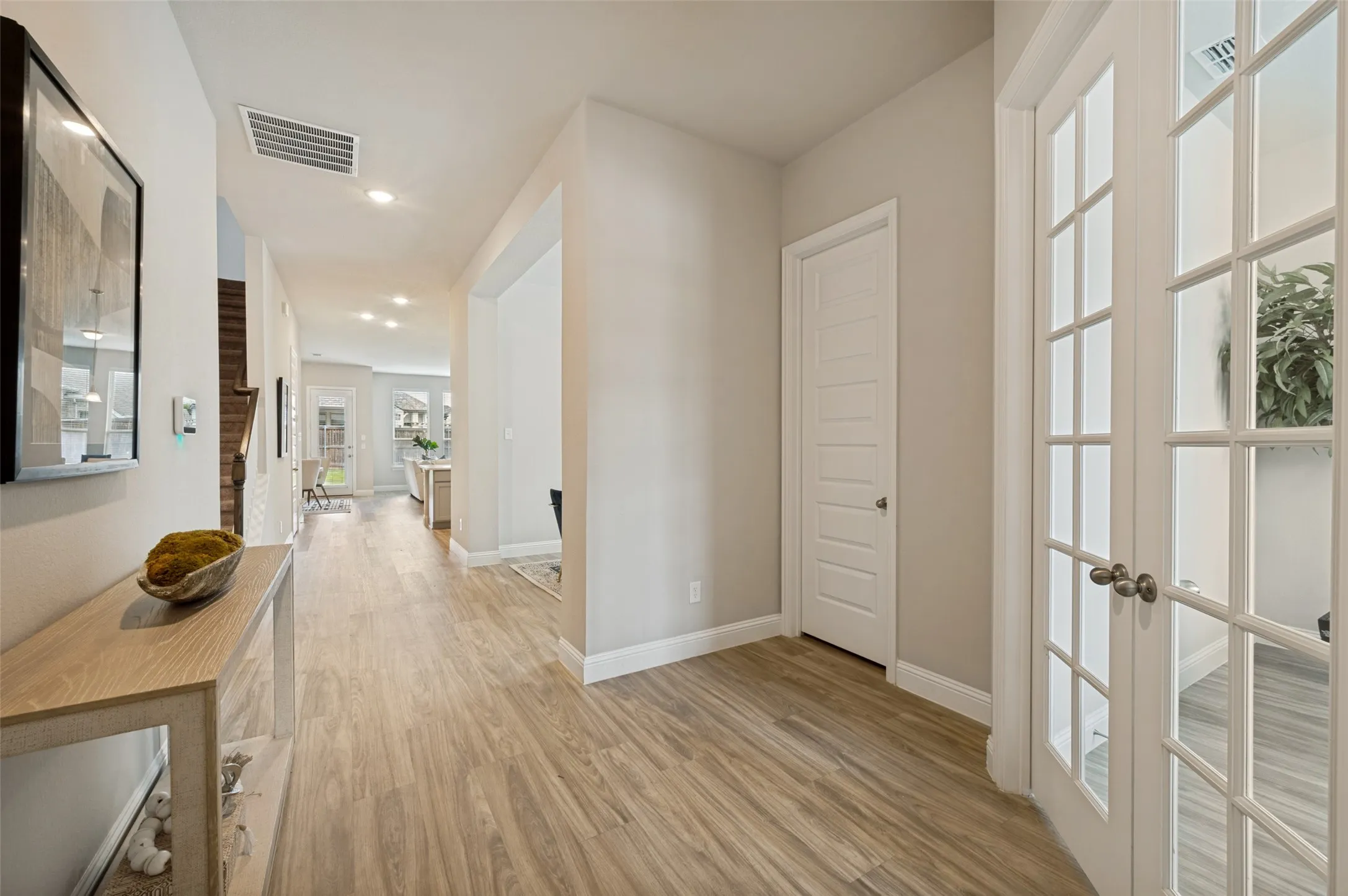 Step inside to a bright and welcoming entryway featuring beautiful wood-look flooring, crisp neutral tones, and abundant natural light. The spacious foyer creates an inviting first impression and offers a seamless flow into the main living areas, setting the stage for the home's open and airy design.