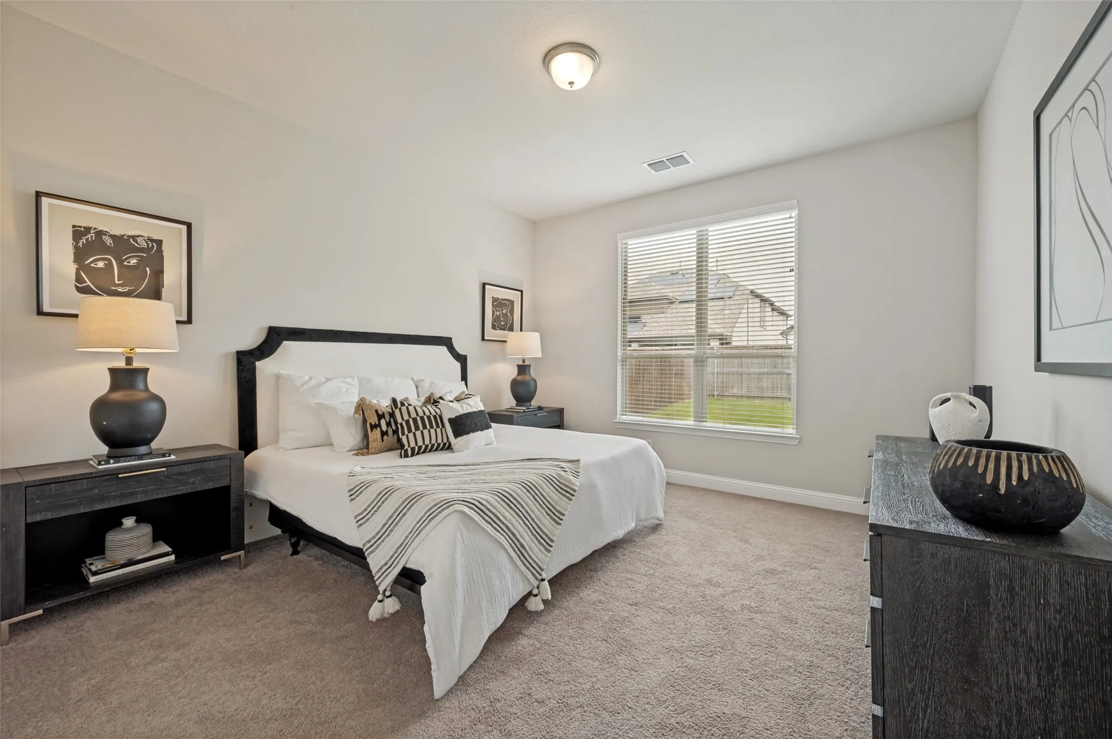 Spacious and private primary suite featuring large windows, plush carpeting, and plenty of room for a sitting area or additional furnishings. Designed as a peaceful retreat, this inviting space offers comfort, natural light, and a relaxing atmo