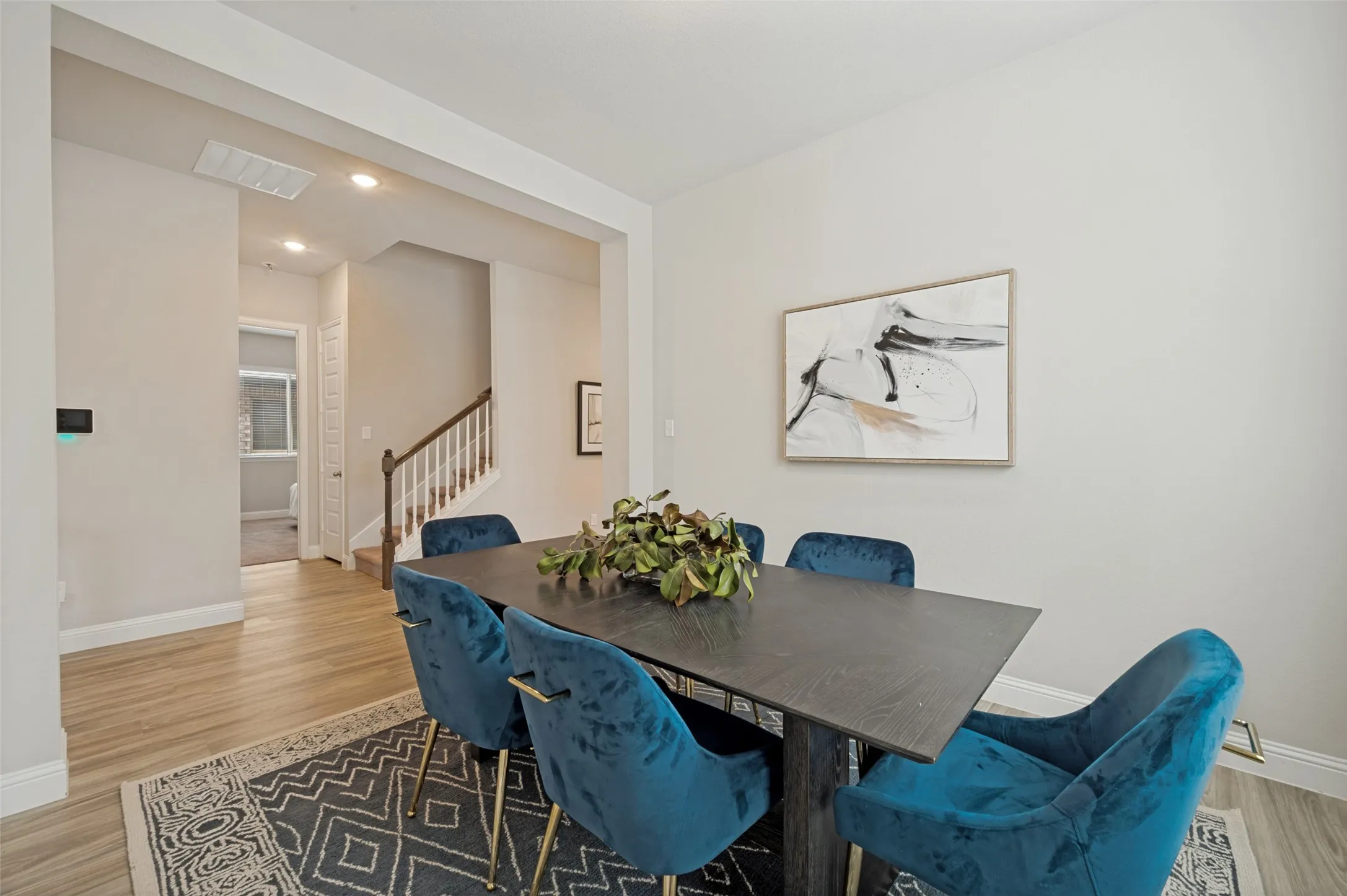 Sophisticated dining room with custom wall detailing, modern designer lighting, and ample space for hosting family dinners or special gatherings. The open-concept layout and elegant finishes create a welcoming setting for entertaining