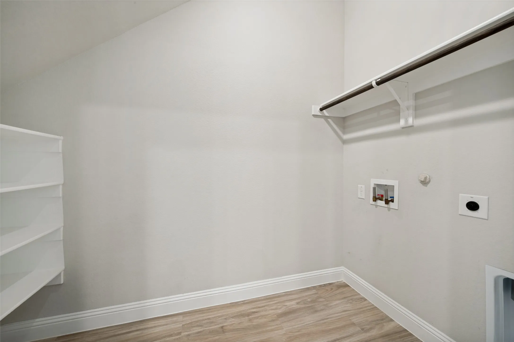 The oversized laundry room offers exceptional functionality with ample space for a full-size washer and dryer, built-in shelving for storage and organization, and room for additional cabinets, a folding station, or a secondary refrigerator. Designed to make everyday chores more convenient, this spacious utility room combines practicality with versatility.