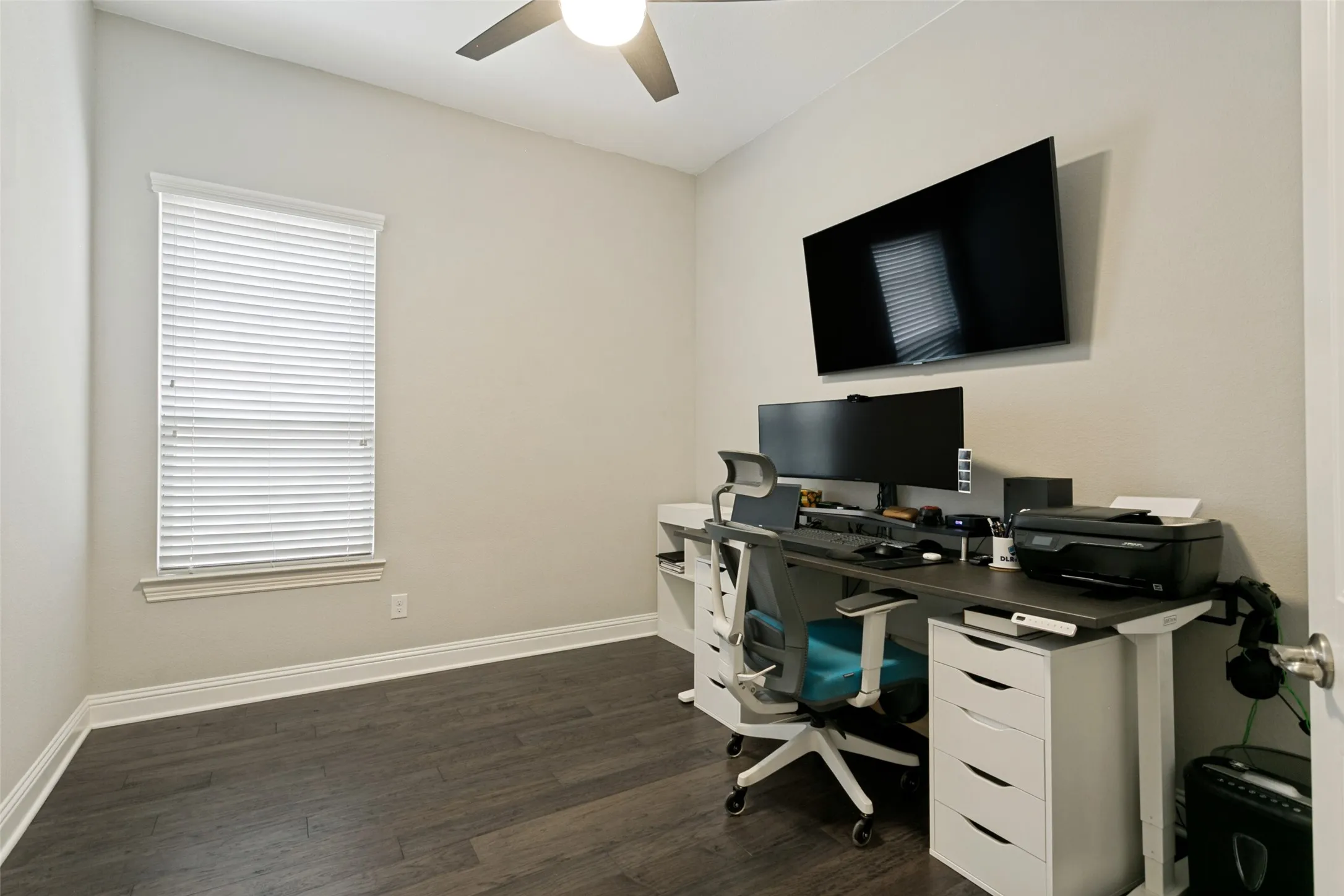 Room featuring dark wood-finish flooring, light neutral walls, and white baseboards