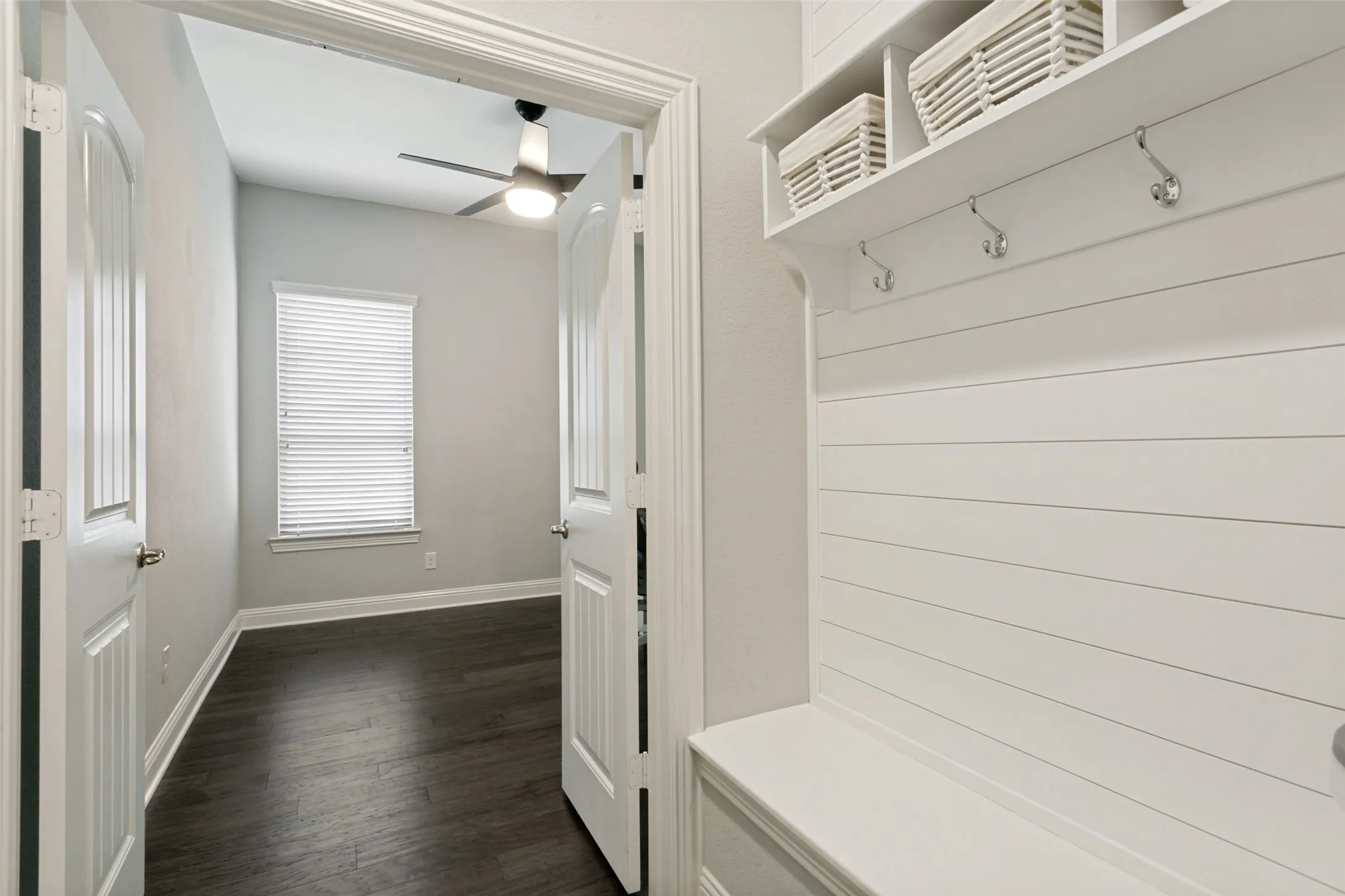 Built-in storage bench with shiplap backing, shelving, and coat hooks