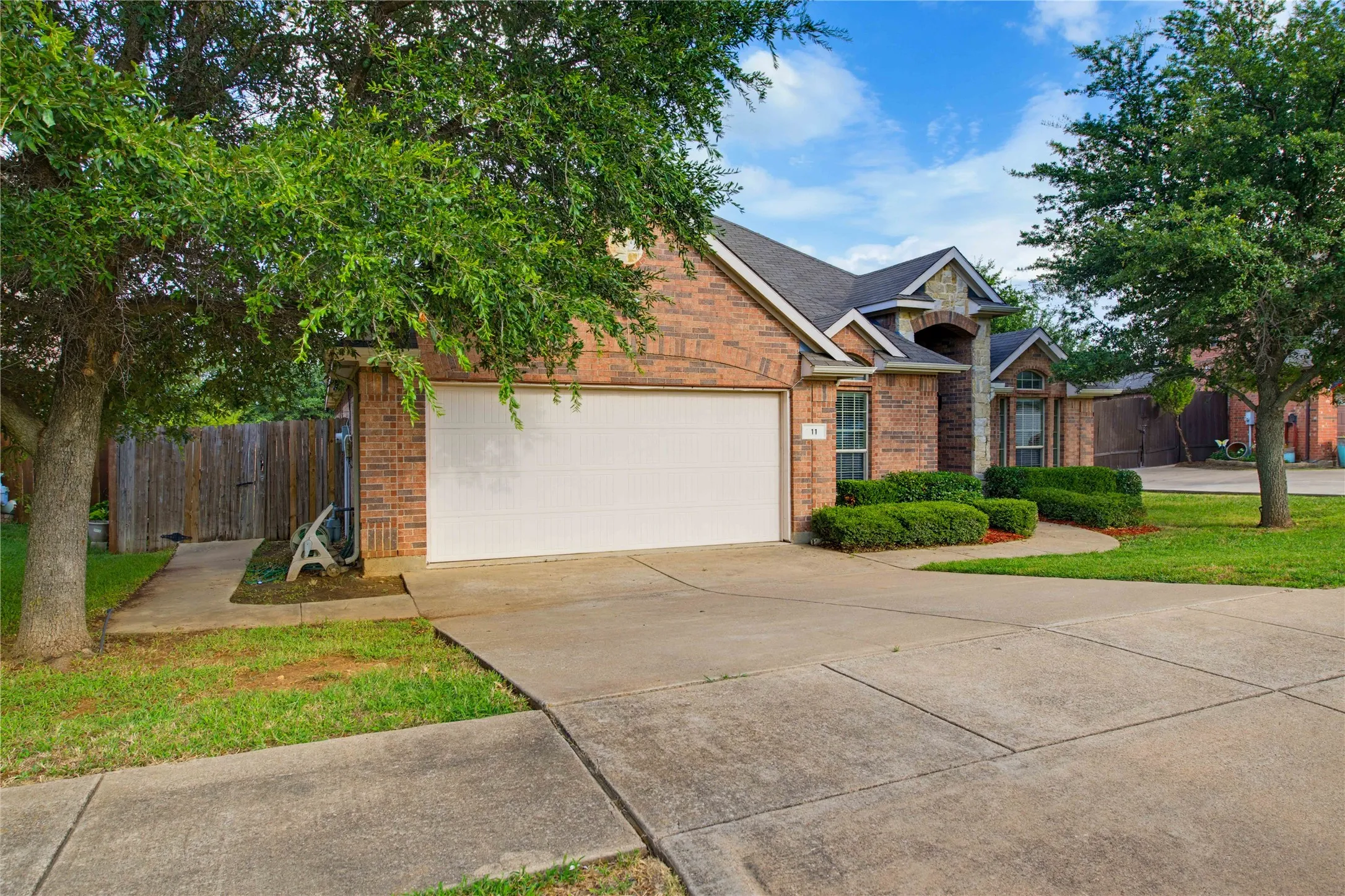 Sidewalk and gate leading the backyard! Brick home with stone accents!