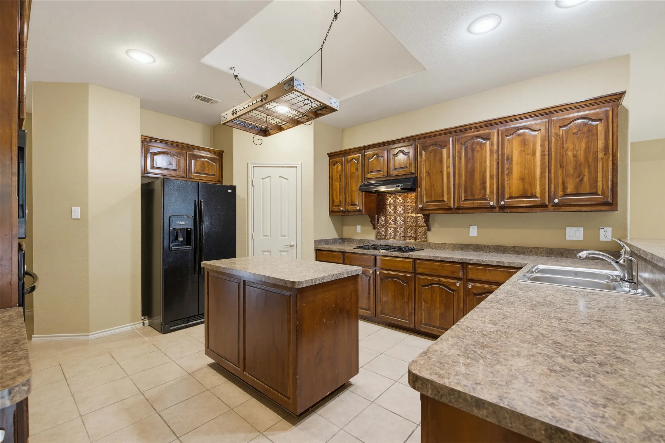 Spacious kitchen with dark cabinets, kitchen island, and pantry for additonal storage!