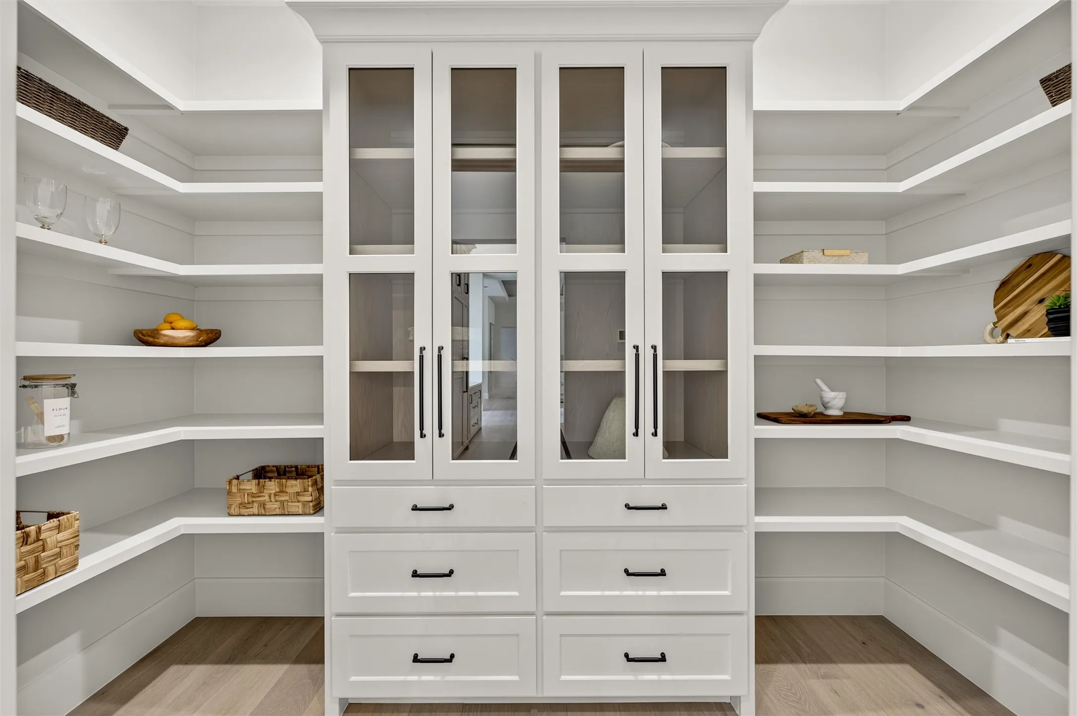 Pantry features beautiful built in cabinet with glass paneled doors.
