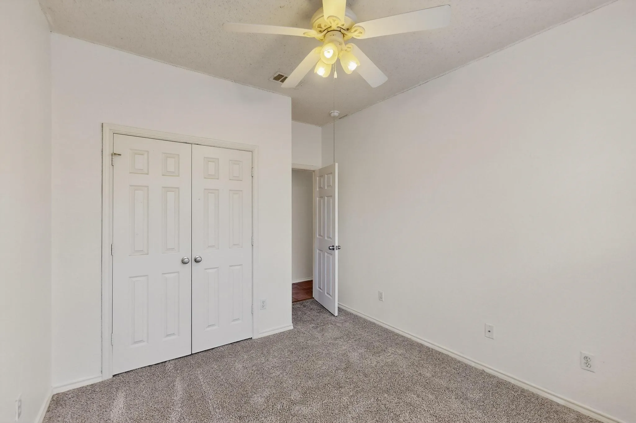 Unfurnished bedroom featuring carpet flooring, a closet, and ceiling fan