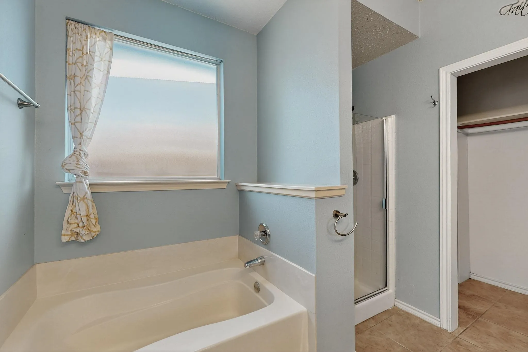 Bathroom with plenty of natural light, a garden tub, a stall shower, and tile patterned floors