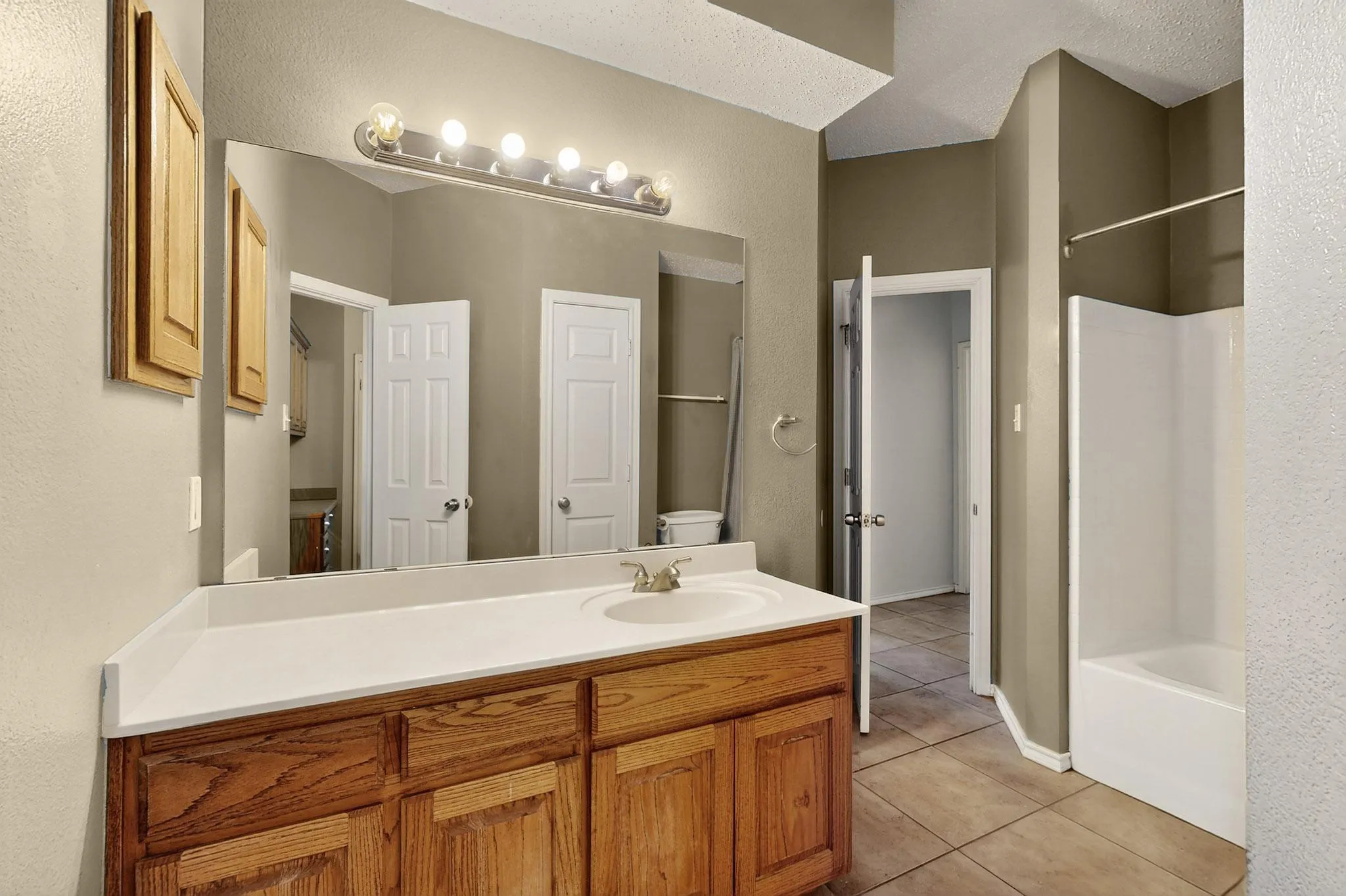 Full bathroom featuring tile patterned flooring, vanity, and tub / shower combination