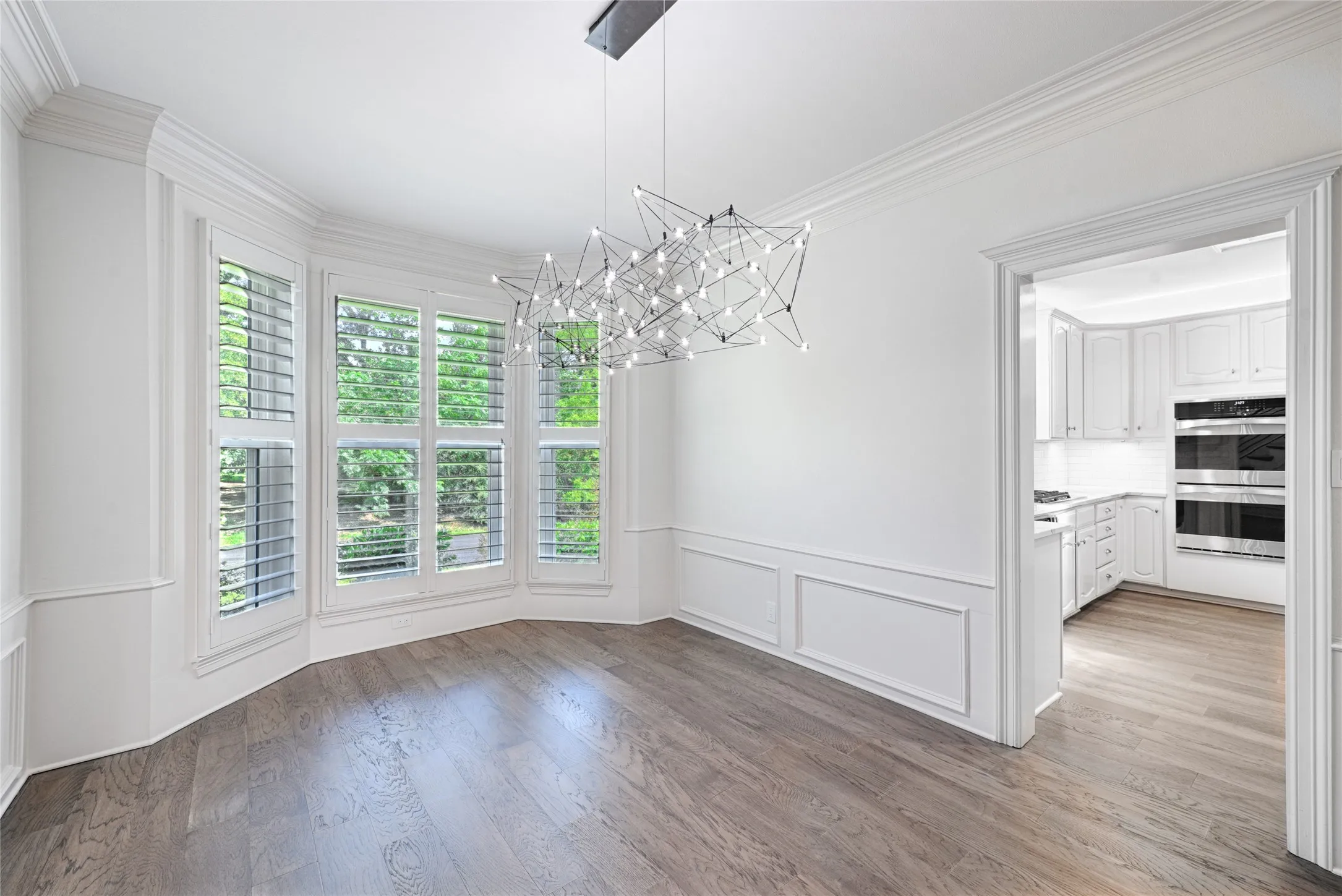 Dining room featuring wood-finish flooring and a contemporary linear chandelier