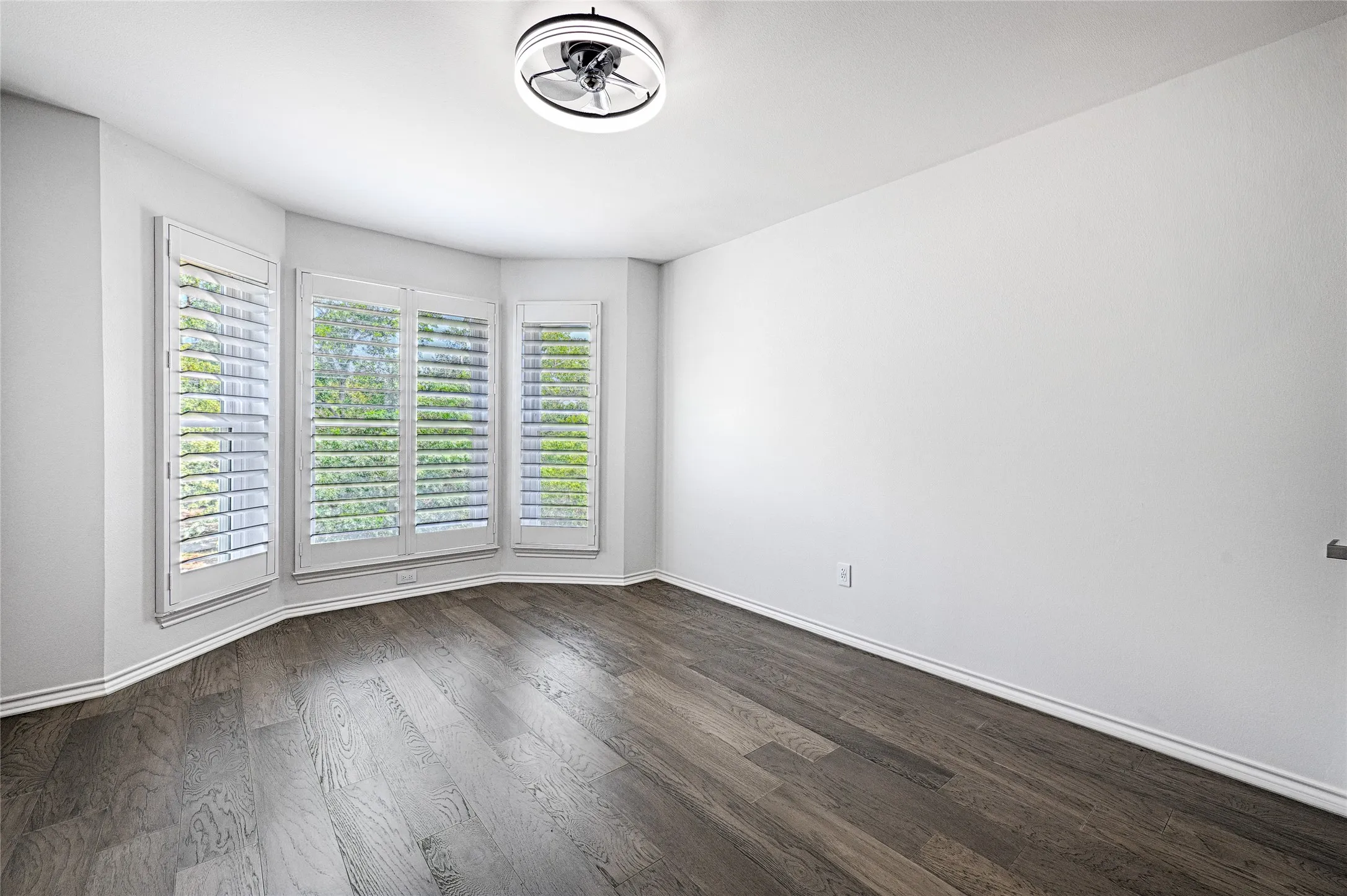 Secondary Bedroom with en-suite bath and walk-in closet, bay window with plantation shutters and wood-finish flooring