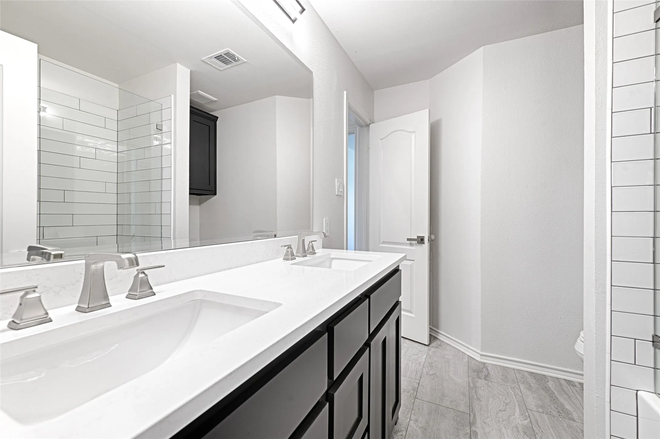 Dual vanity with integrated sinks, brushed nickel faucets, and a white countertop