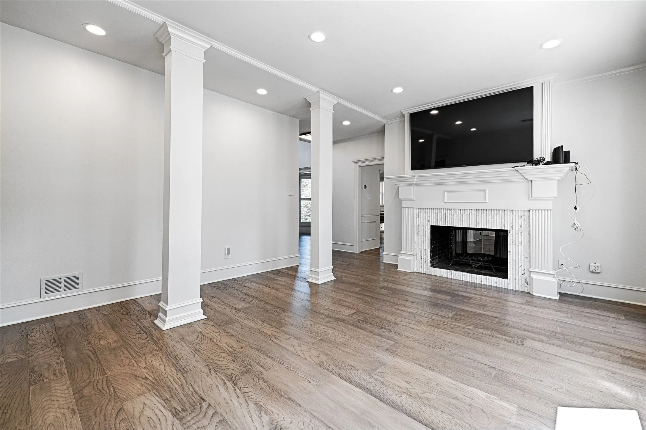 Living area featuring wood-finish flooring, recessed lighting, and white baseboards