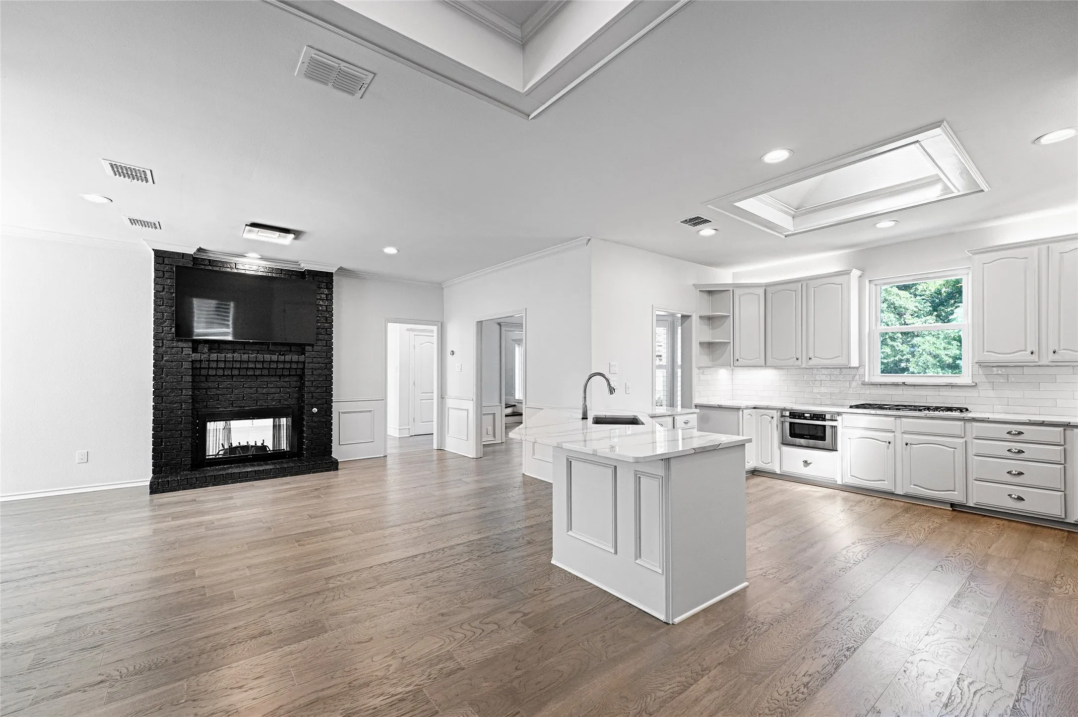 Open-concept living space with light wood-finish flooring