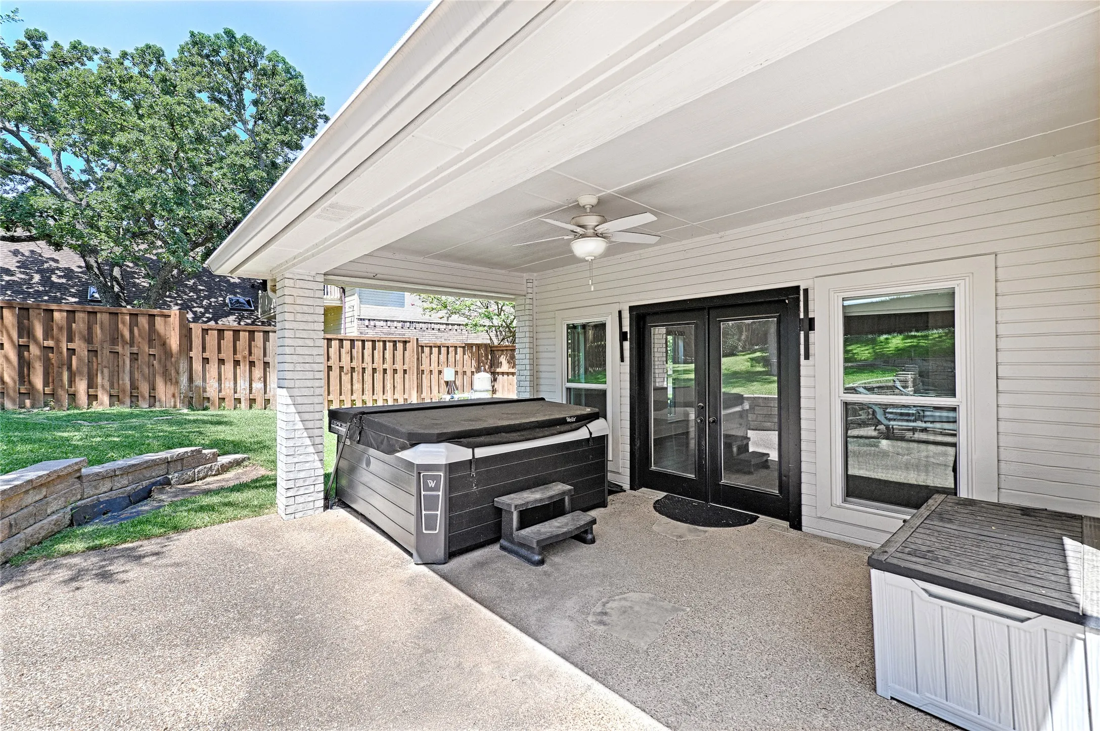 Expansive covered patio featuring an exposed aggregate concrete surface