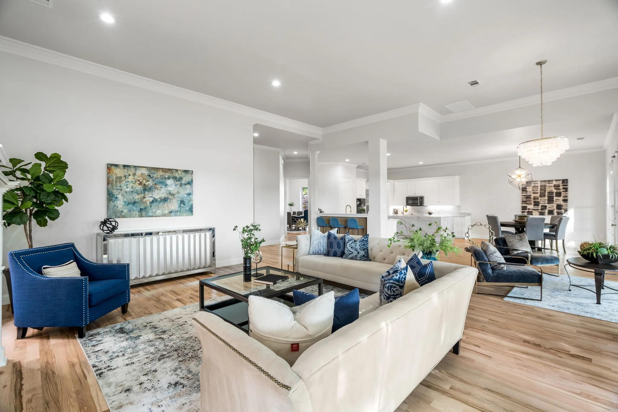 Living room featuring radiator, light wood-type flooring, ornamental molding, and a chandelier