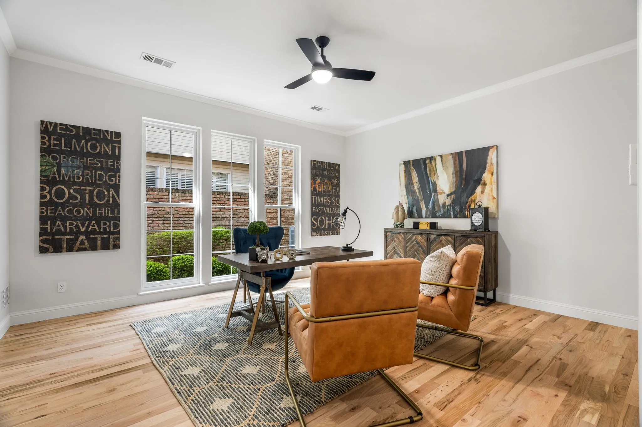 Home office with crown molding, light wood-style floors, and a ceiling fan
