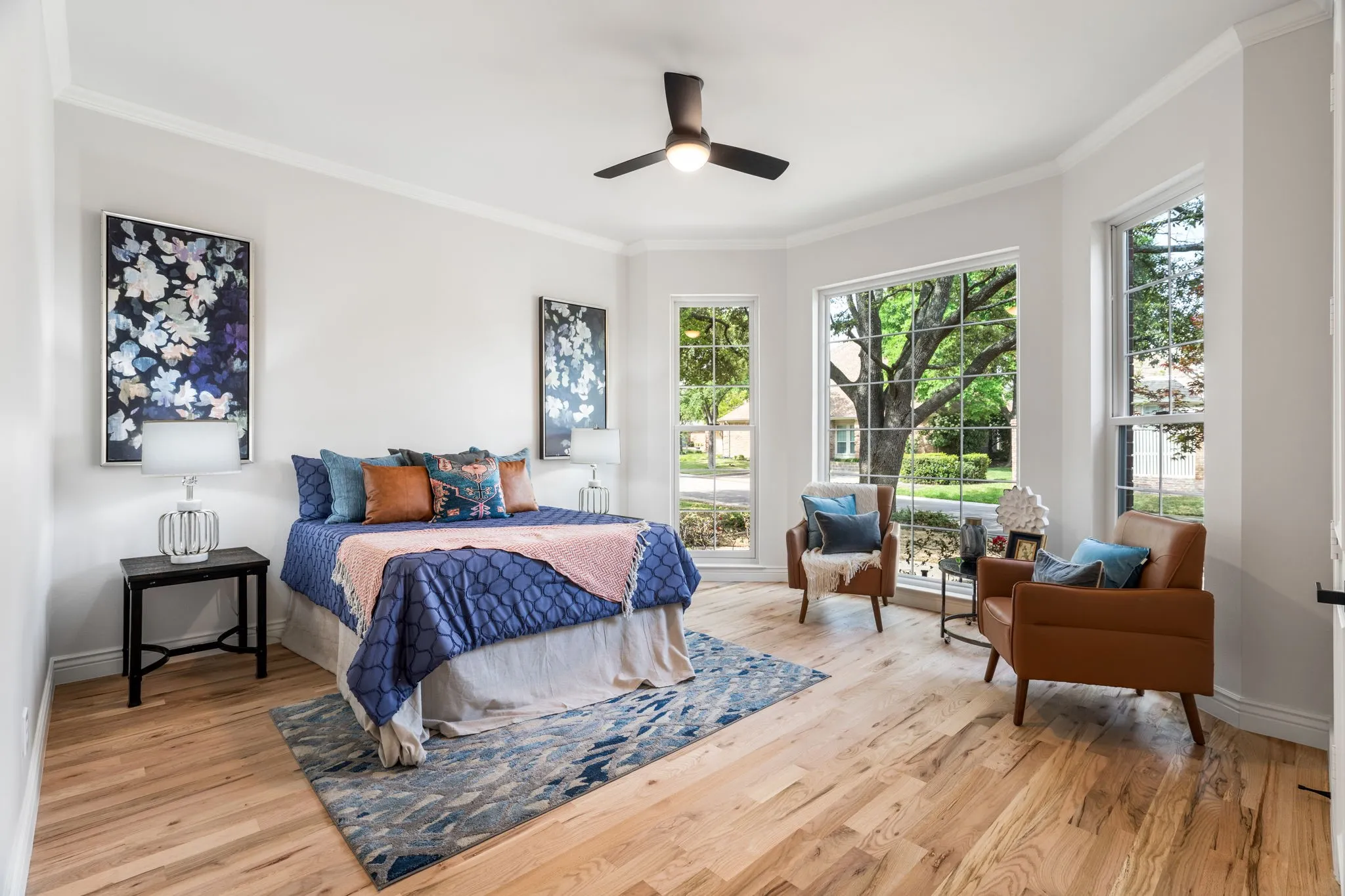 Bedroom featuring ceiling fan, ornamental molding, and light wood-style flooring