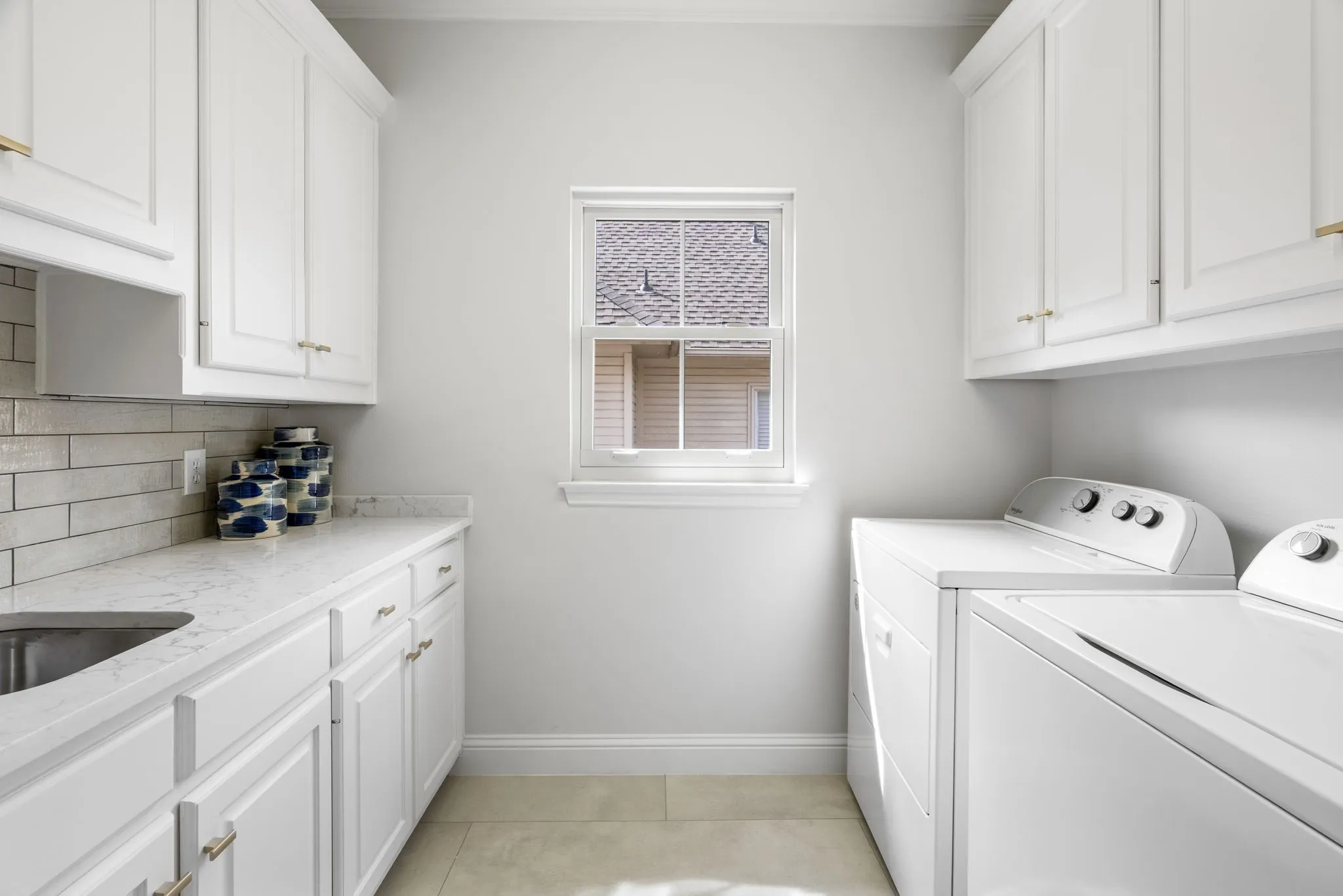 Laundry area featuring washer and dryer, cabinet space, and light tile patterned floors