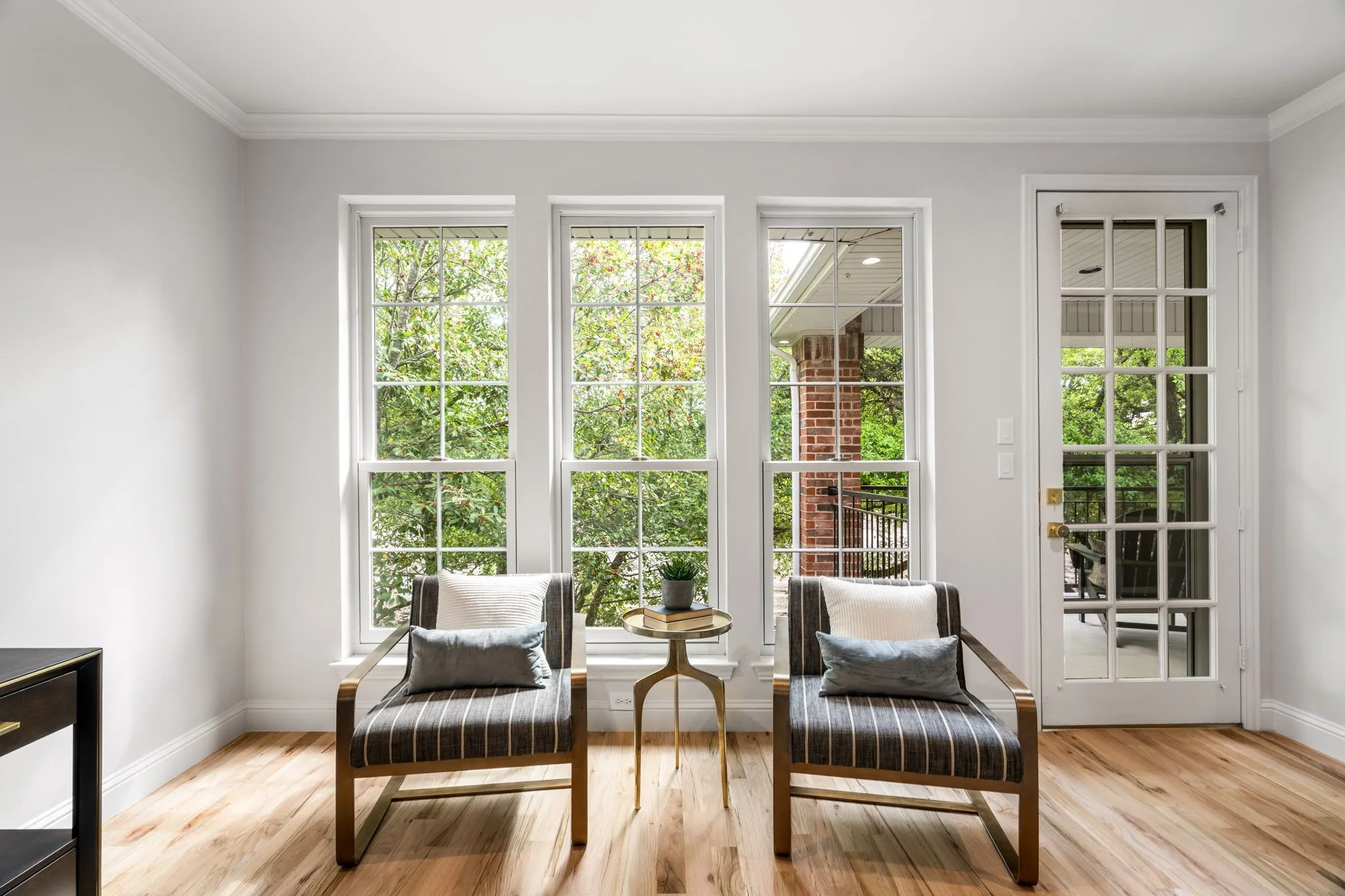 Sitting room with ornamental molding and light wood-type flooring