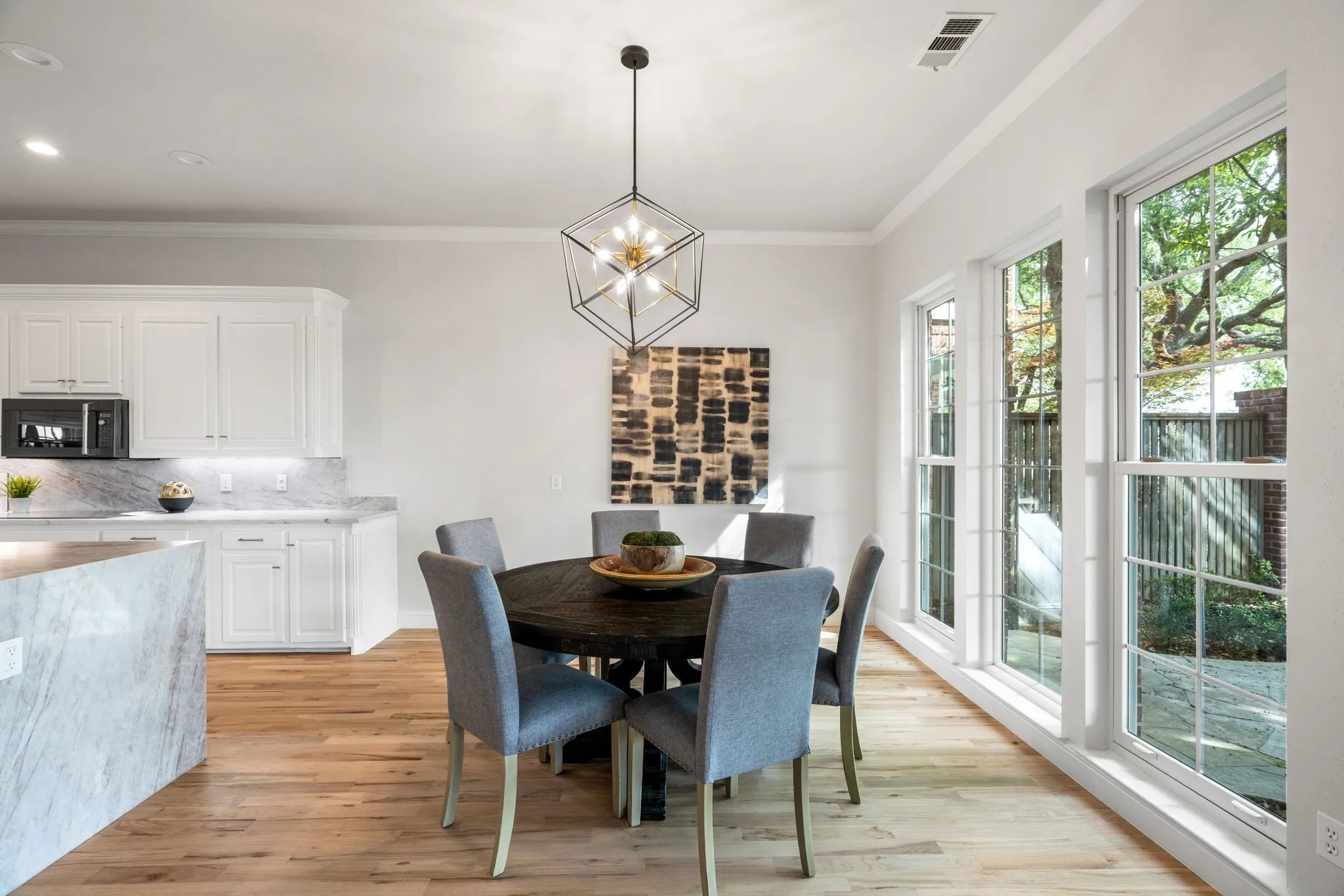 Dining room featuring suspended lighting, light wood-style floors, and ornamental molding