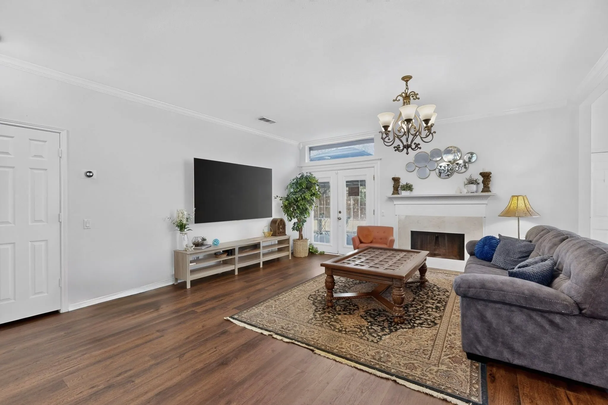 Living area featuring dark wood-finish flooring and white crown molding