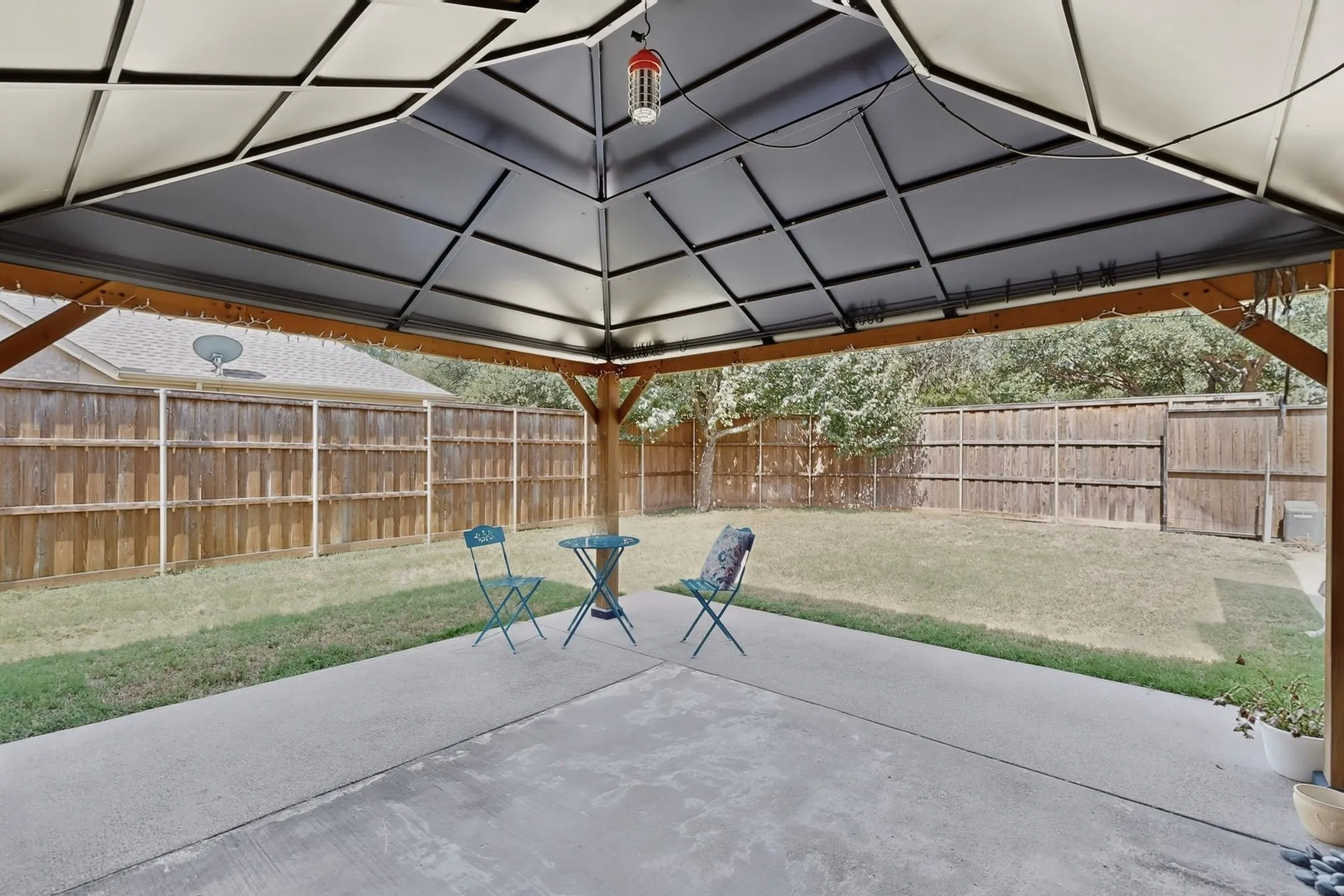 Concrete patio with a built-in gazebo featuring a dark canopy