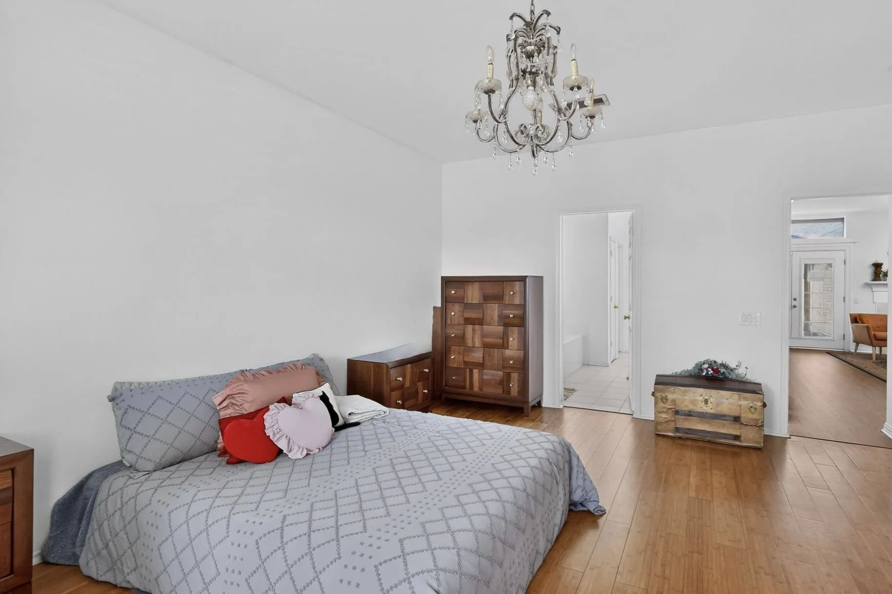 Bright interior room featuring a crystal chandelier, wood-finish flooring, and crisp white walls