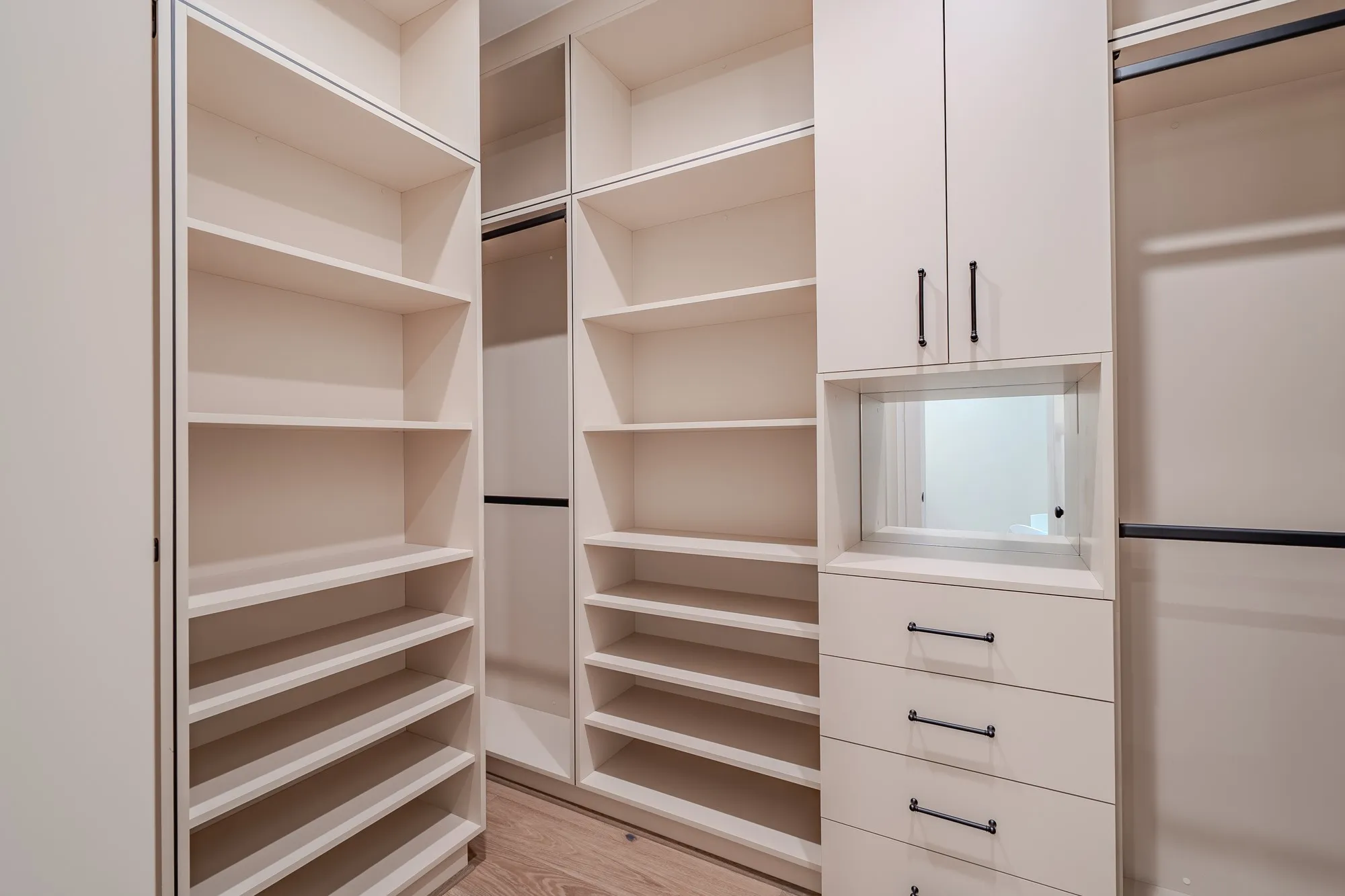 Walk in closet with light wood finished floors