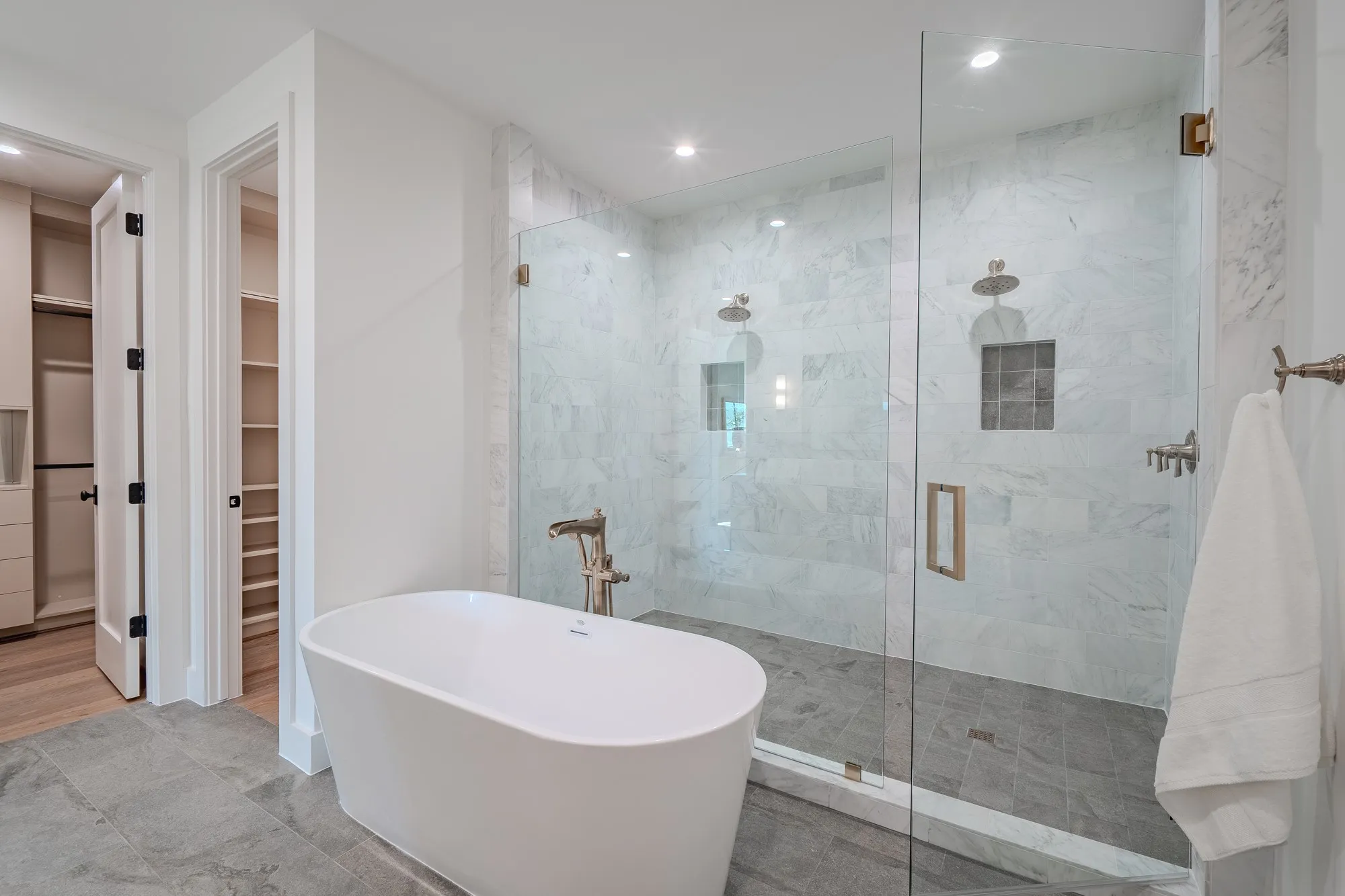 Full bathroom with a walk in closet, a stall shower, a soaking tub, and recessed lighting