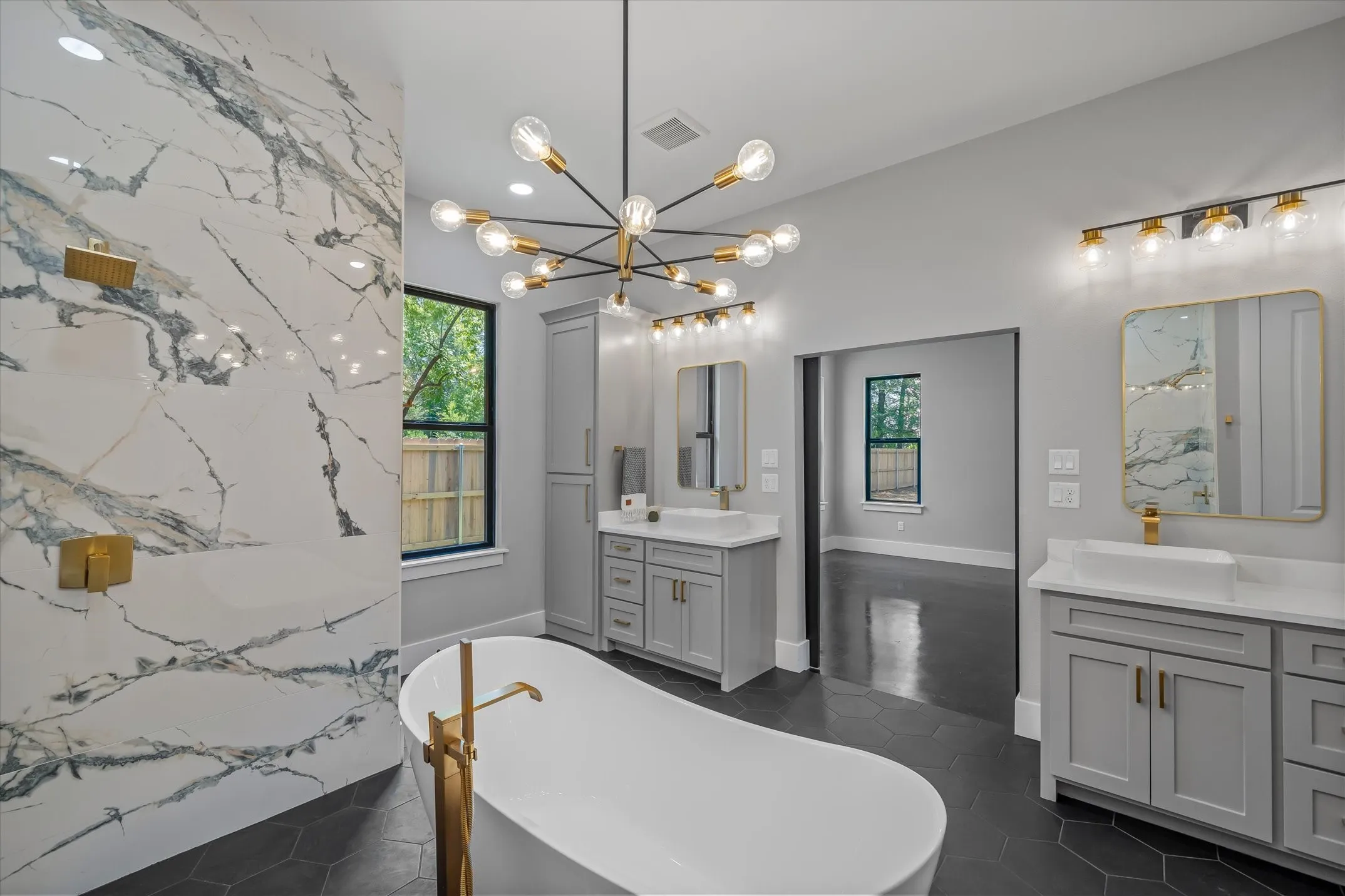 Freestanding soaking tub with gold-finish floor-mounted faucet