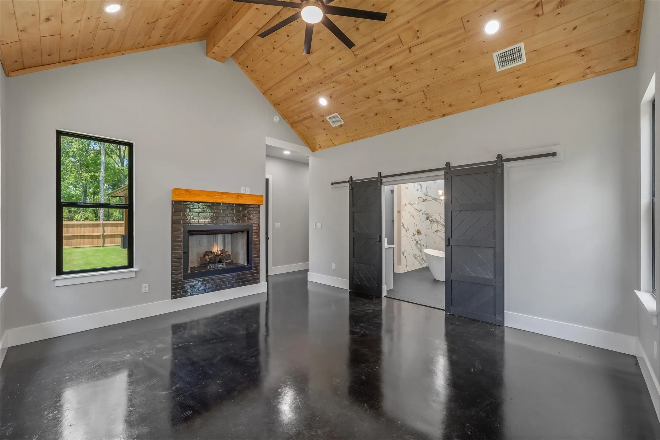 Vaulted wood-plank ceiling with a ceiling fan and recessed lighting
